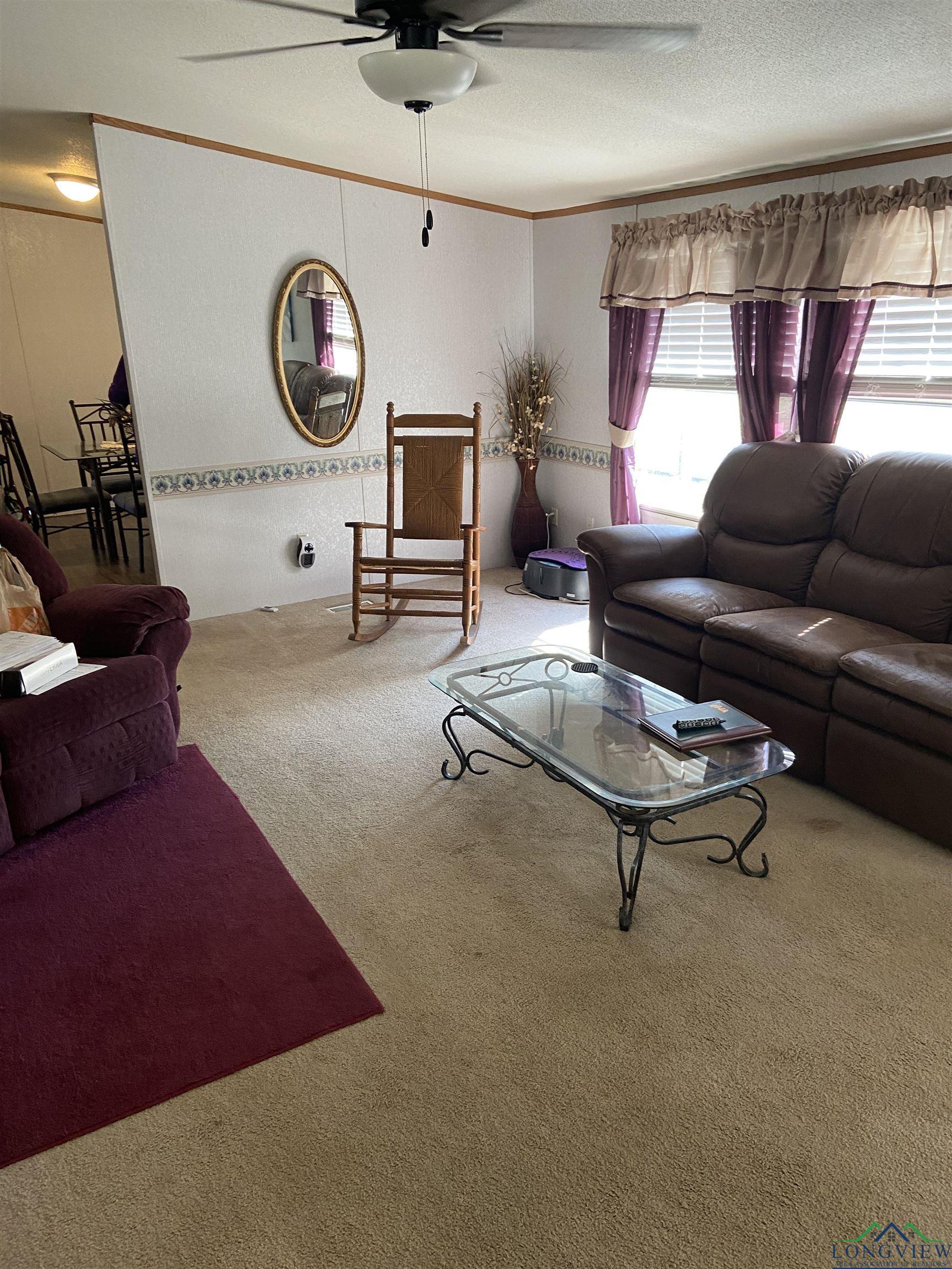 Image 3: Carpeted living area with a textured ceiling, ceiling fan, and crown molding, Living Room