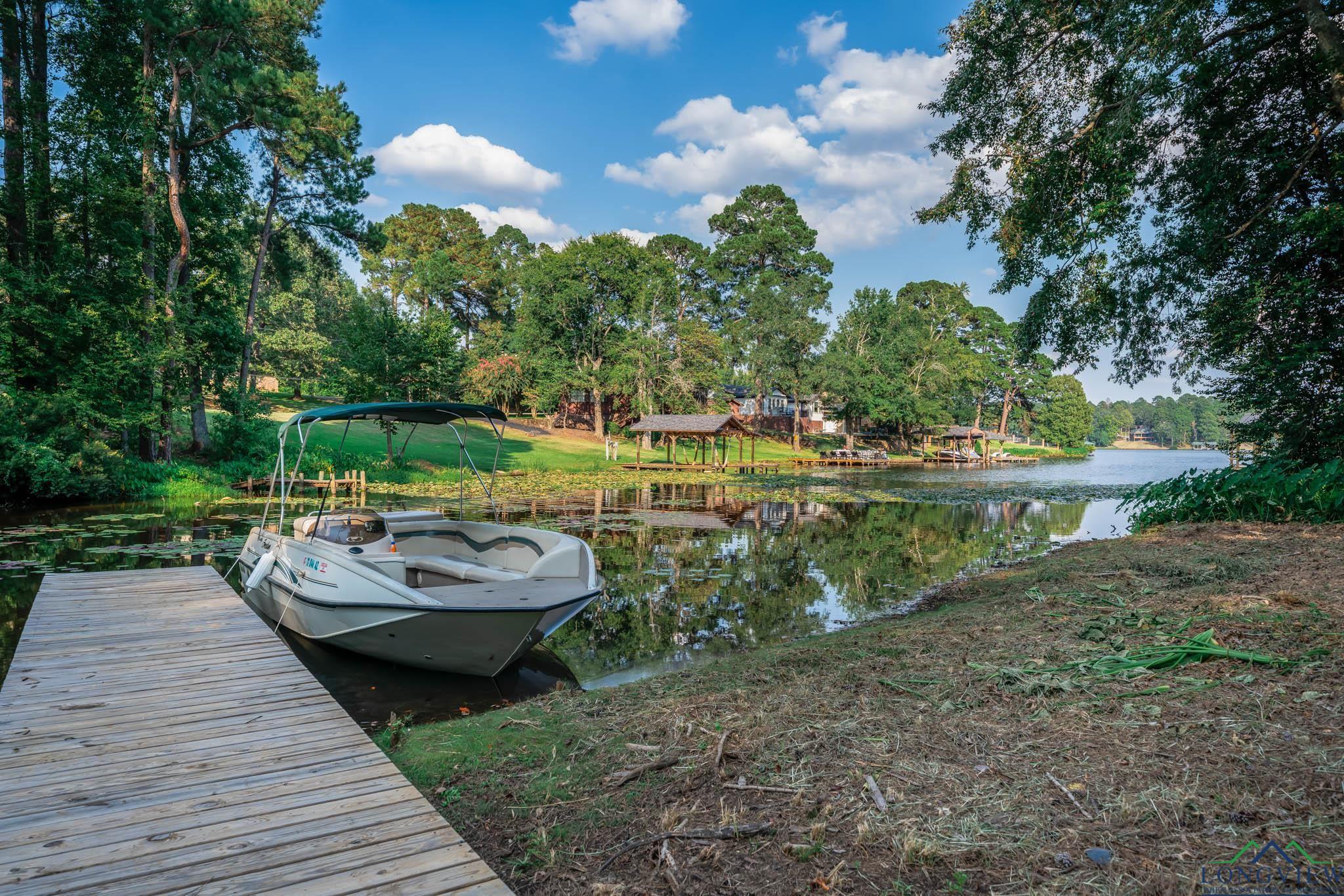 Image 2: Dock featuring a water view and view of wooded area, Dock