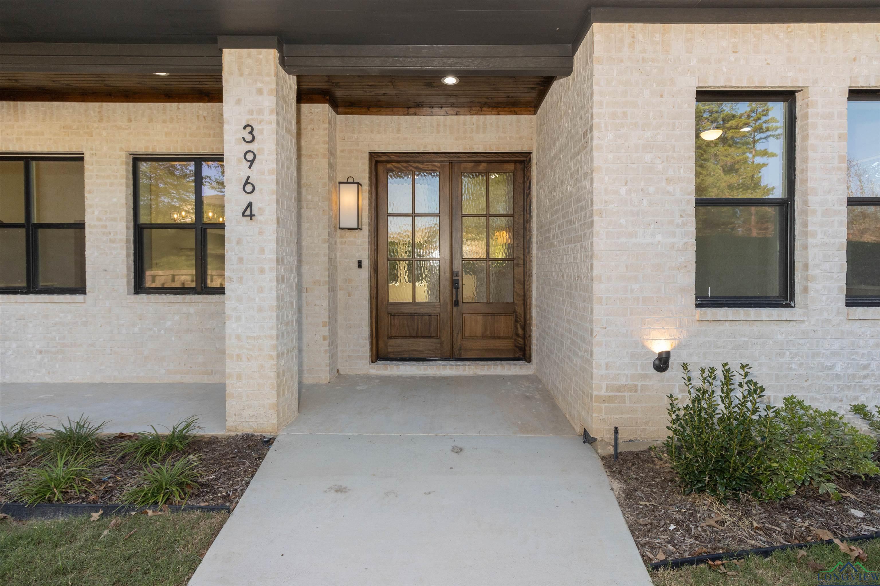 Image 2: Property entrance featuring brick siding, covered porch, and french doors, Entry