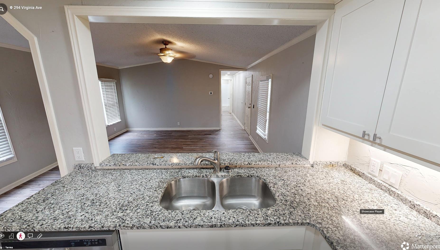 Image 1: Kitchen pass-through featuring a double basin stainless steel sink, granite-style countertops, white cabinetry with silver hardware, and integrated under-cabinet lighting, Kitchen