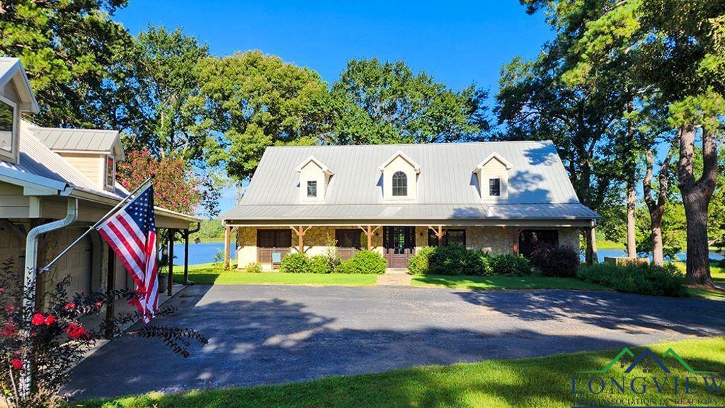 Image 0: Cape cod house featuring covered porch and a metal roof, Front Of Structure