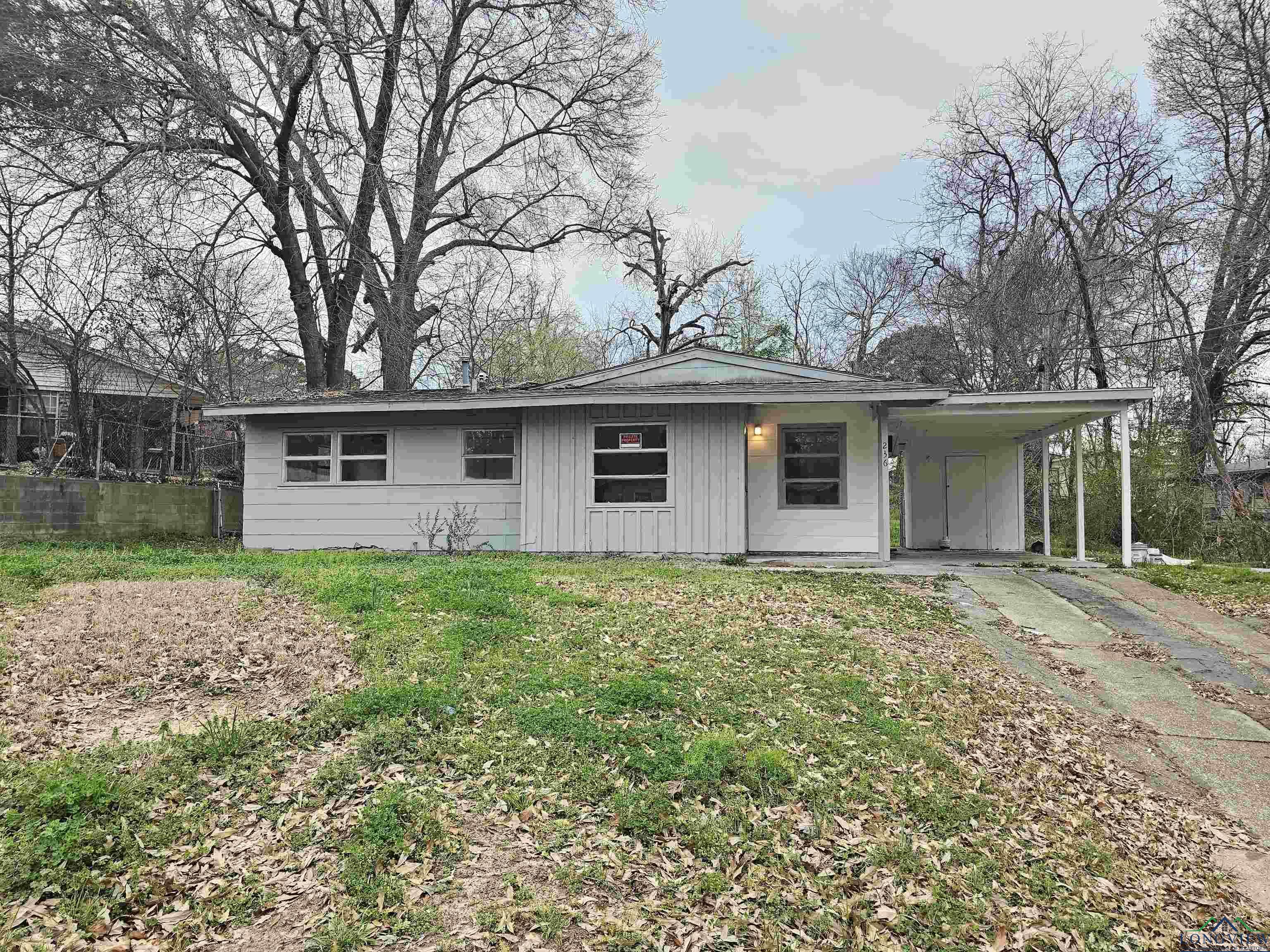 Image 0: View of front facade featuring a carport, board and batten siding, driveway, a porch, and a front yard, Front Of Structure