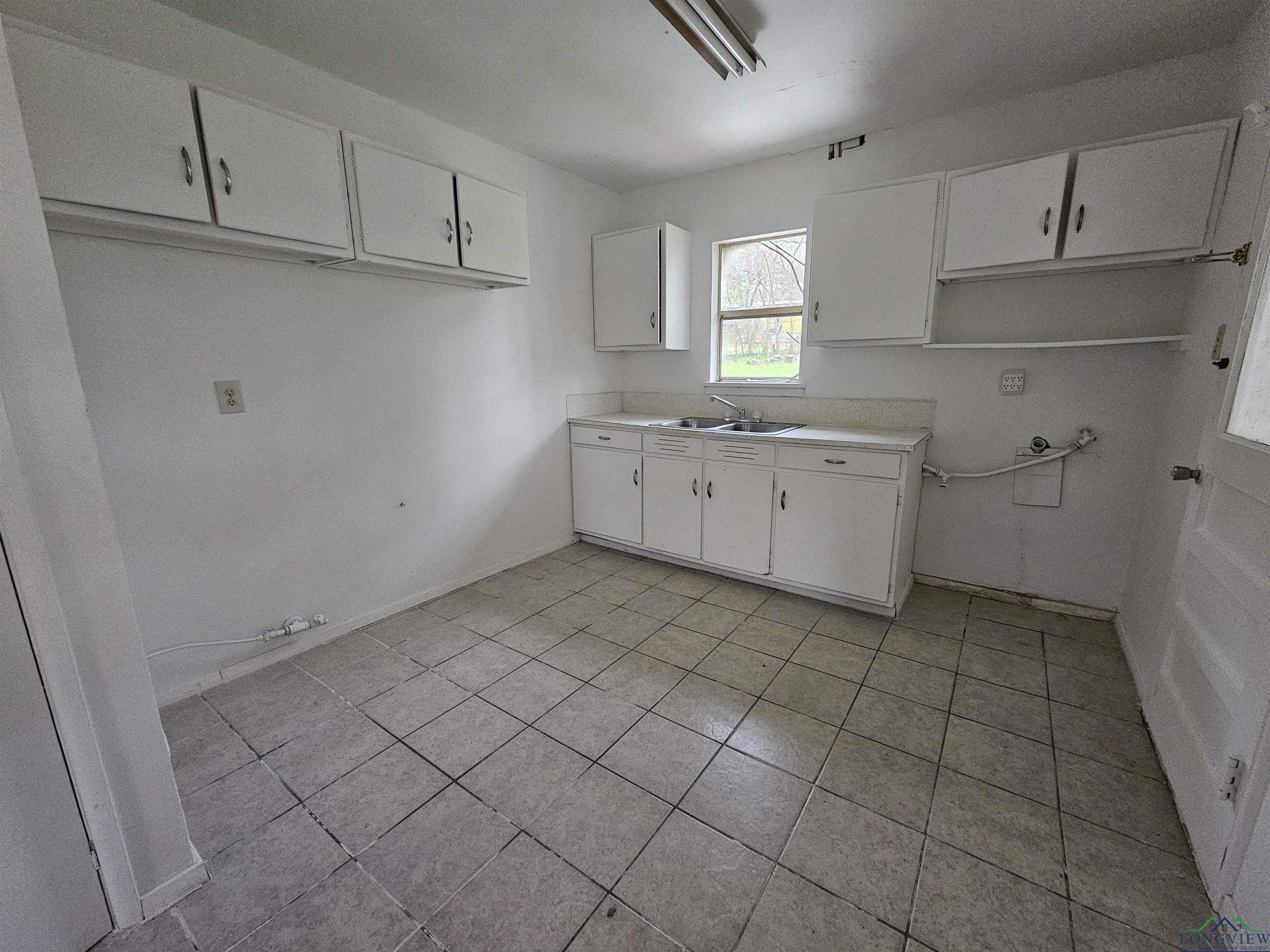 Image 3: Kitchen with light countertops, white cabinetry, and light tile patterned floors, Kitchen
