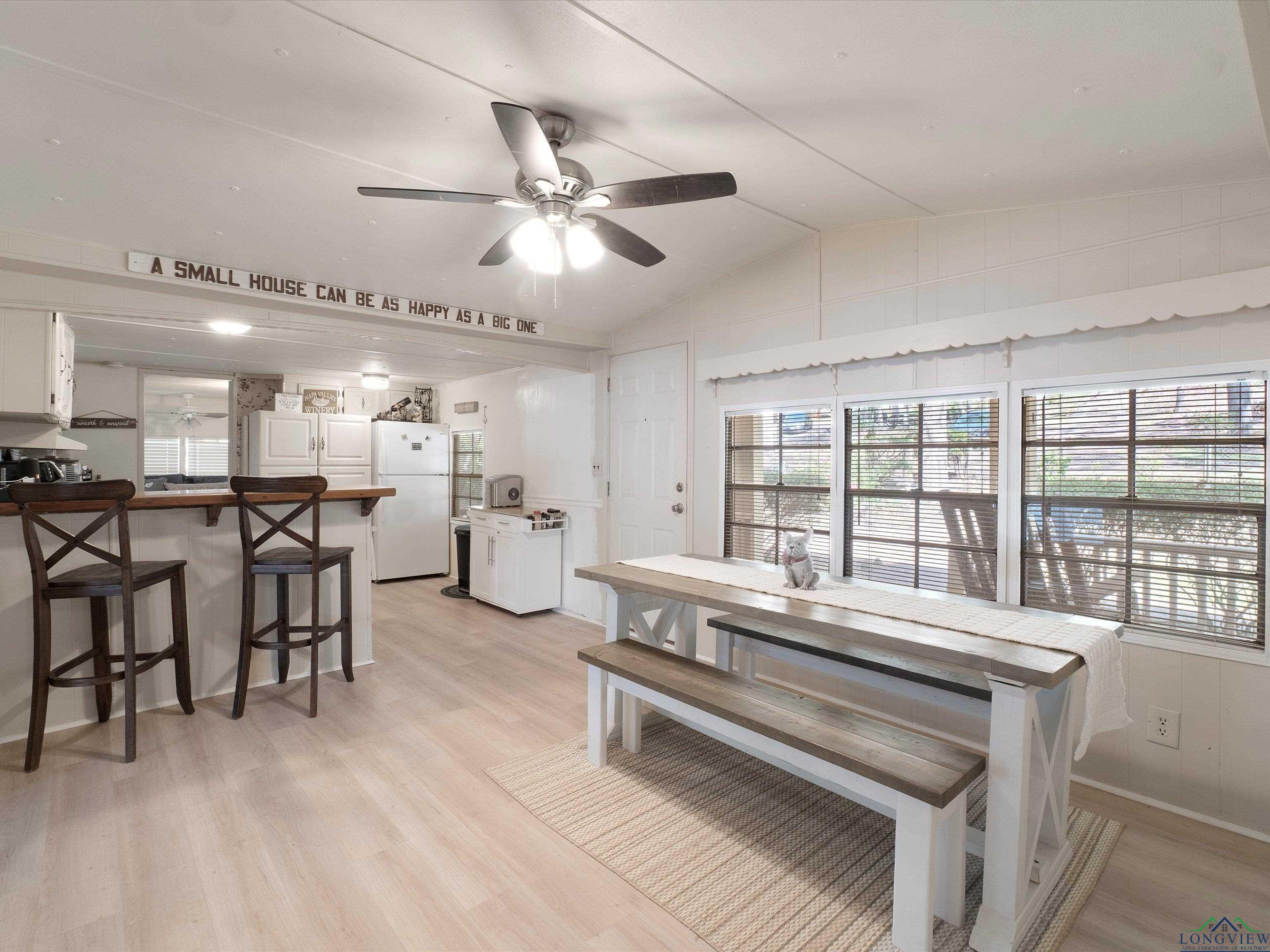 Image 3: Dining room with light wood finished floors, vaulted ceiling, and a ceiling fan, Dining Area