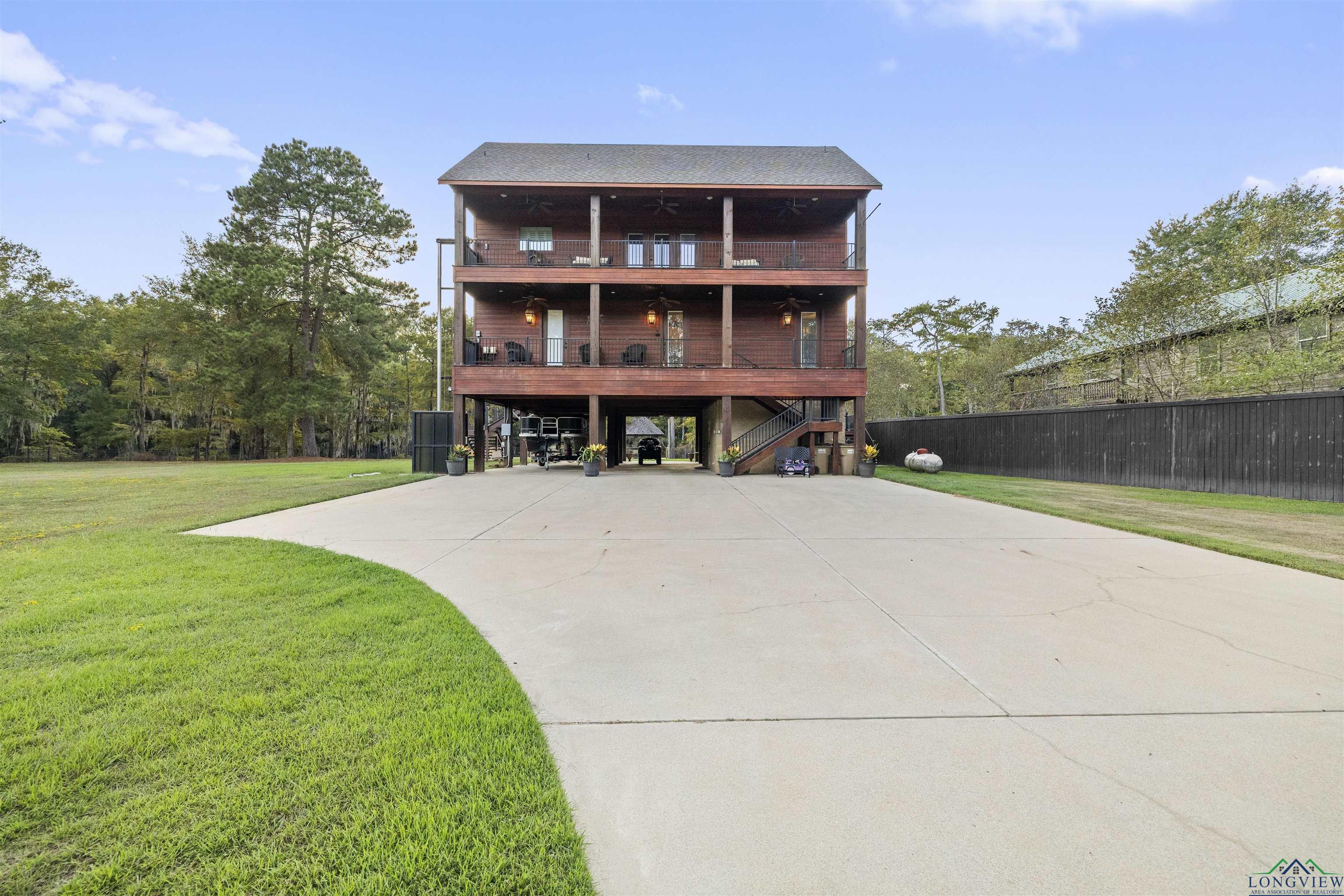 Image 3: Front of property with a lawn, a carport, stairway, driveway, and a deck, Front of Structure