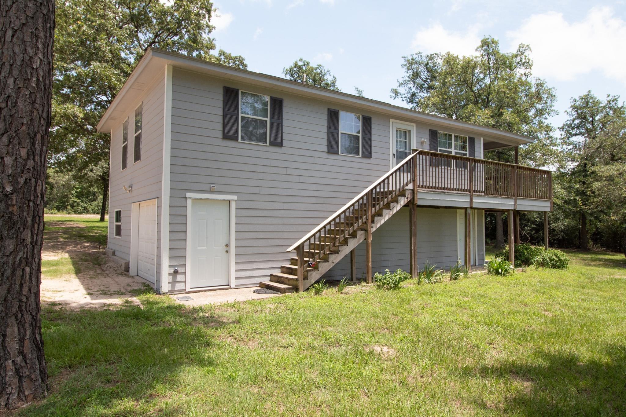 Image 1: Back of house with stairs, a lawn, and a deck, Back Of Structure