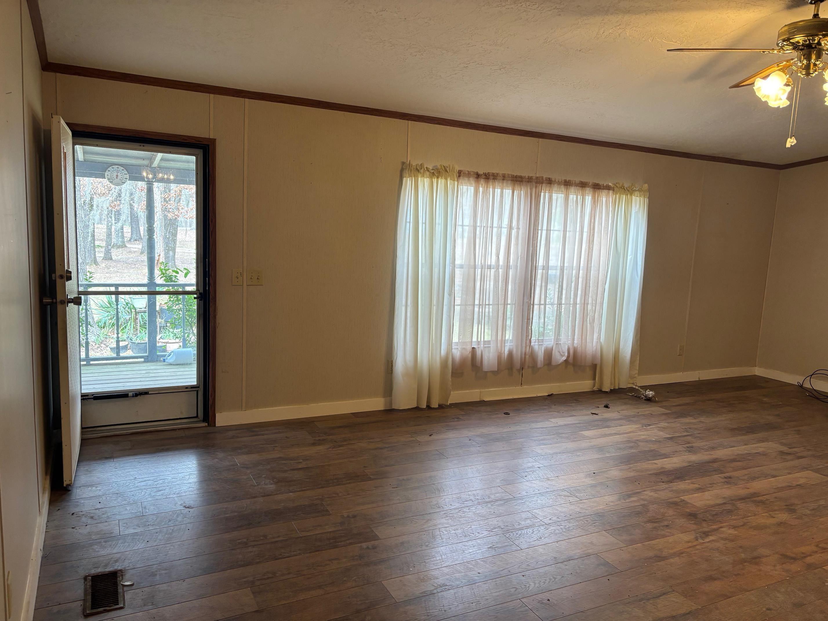 Image 1: Unfurnished room featuring ornamental molding, dark wood-style floors, ceiling fan, and a textured ceiling, Living Room