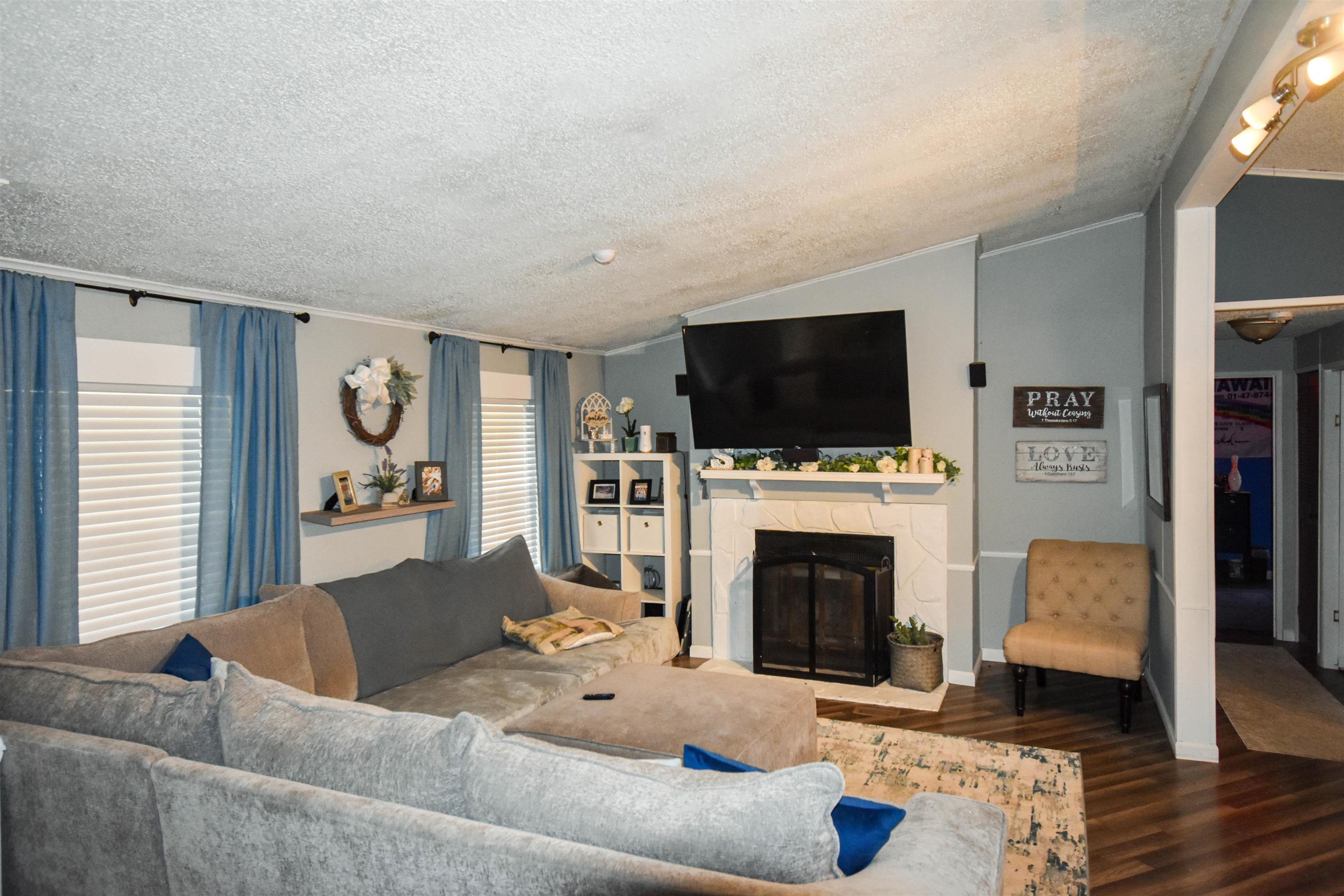 Image 2: Living area featuring a fireplace and wood finished floors, Living Room