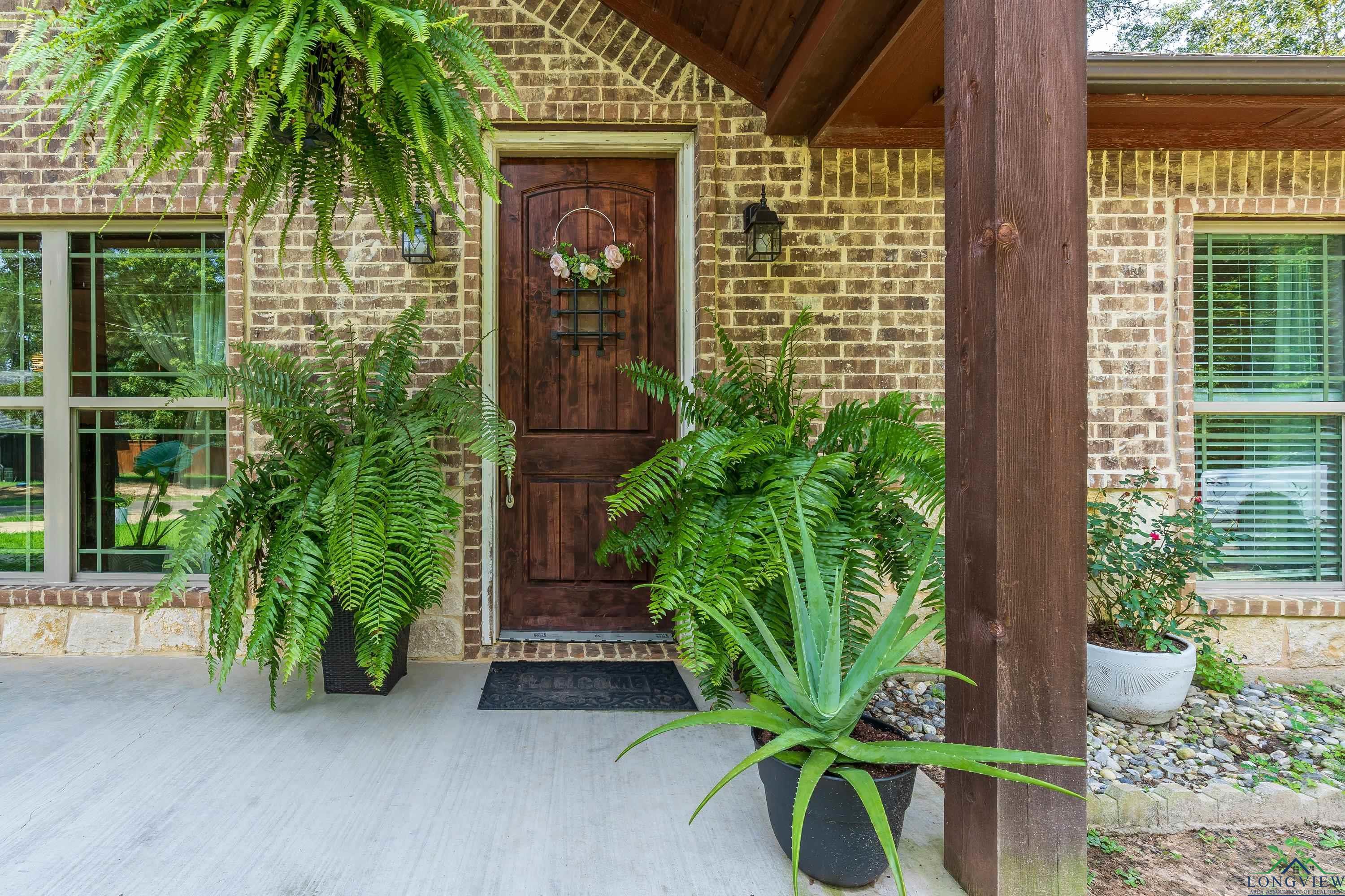 Image 1: Entrance to property featuring brick siding and covered porch, Entry