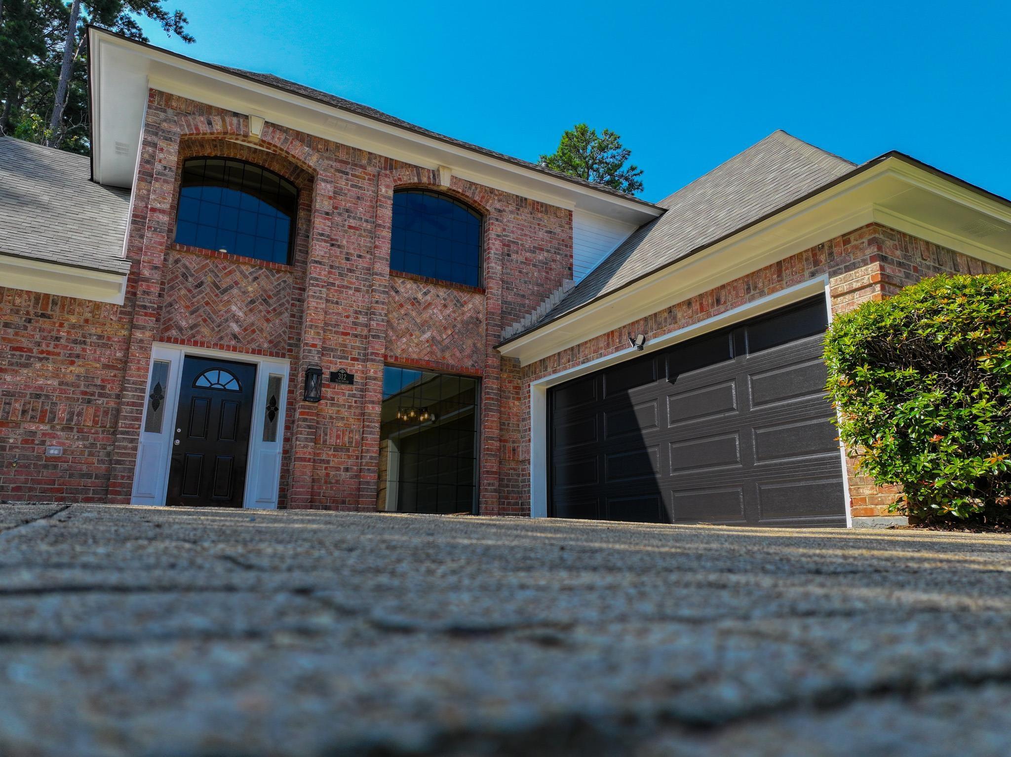 Image 1: View of front of property featuring roof with shingles, brick siding, and an attached garage, Front Of Structure