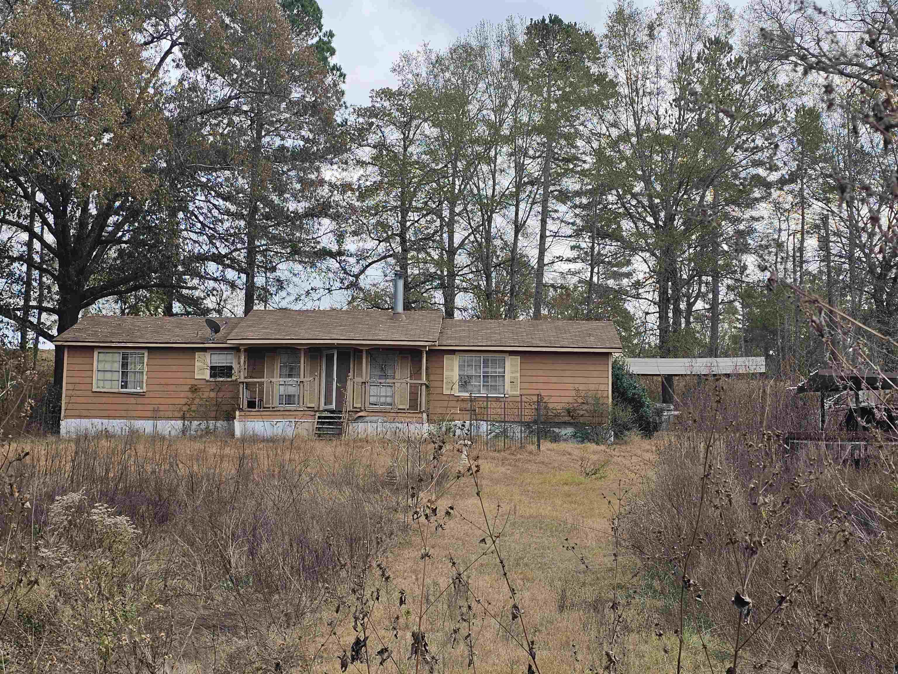 Image 1: View of front facade with covered porch and a carport, Front Of Structure