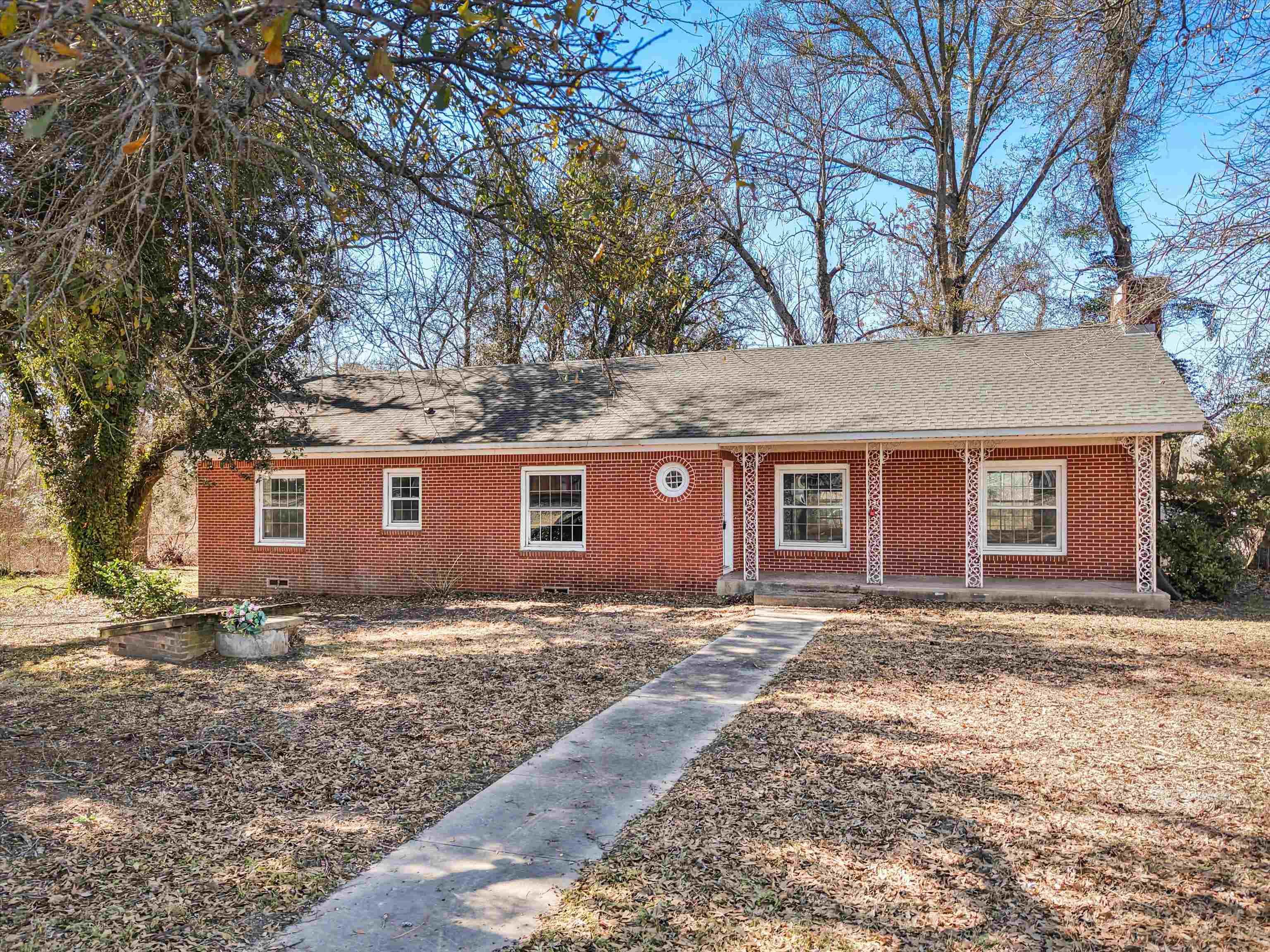 Image 0: Ranch-style home with covered porch, brick siding, a shingled roof, and crawl space, Front Of Structure