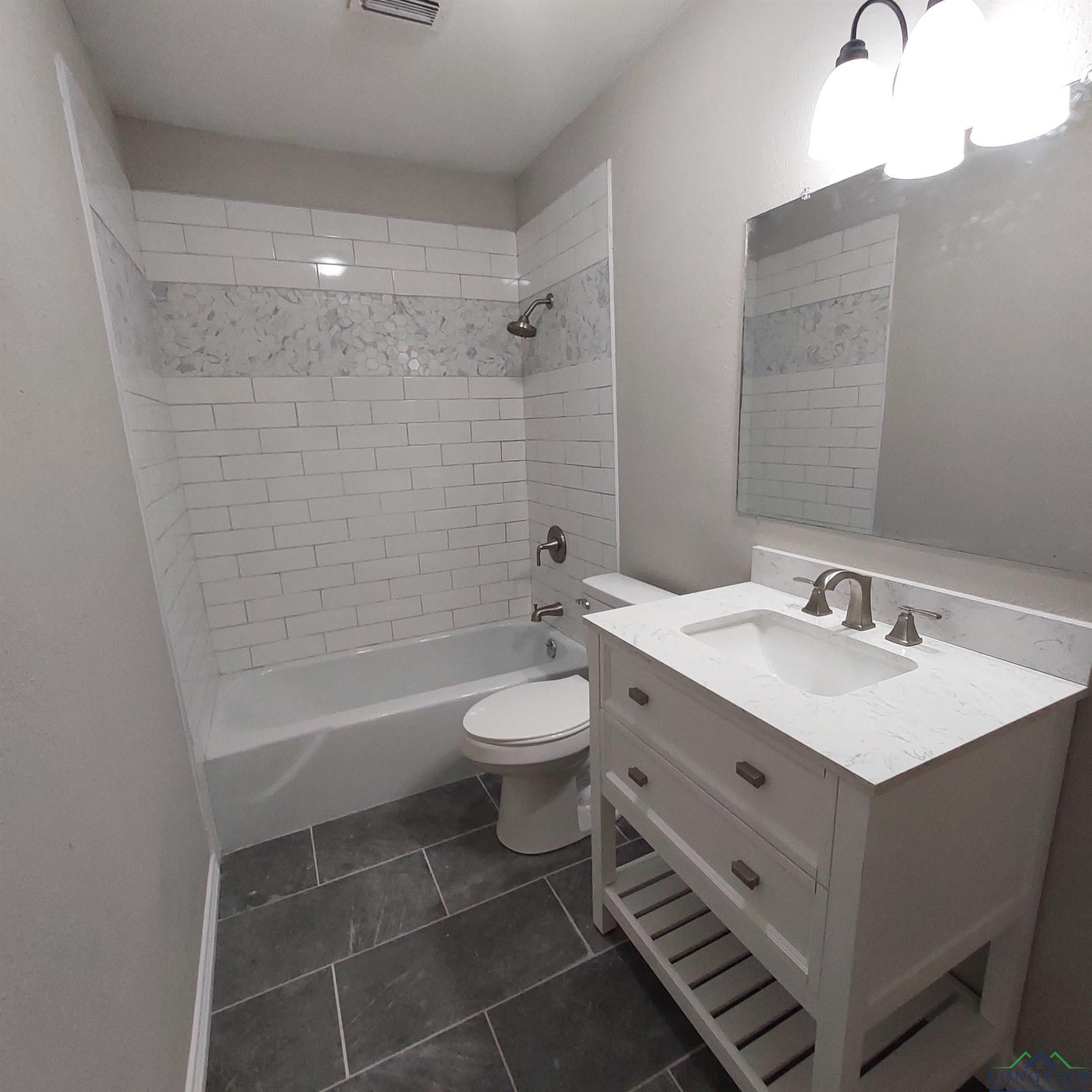 Image 3: Full bathroom featuring vanity, bathing tub / shower combination, and tile patterned flooring, Bathroom