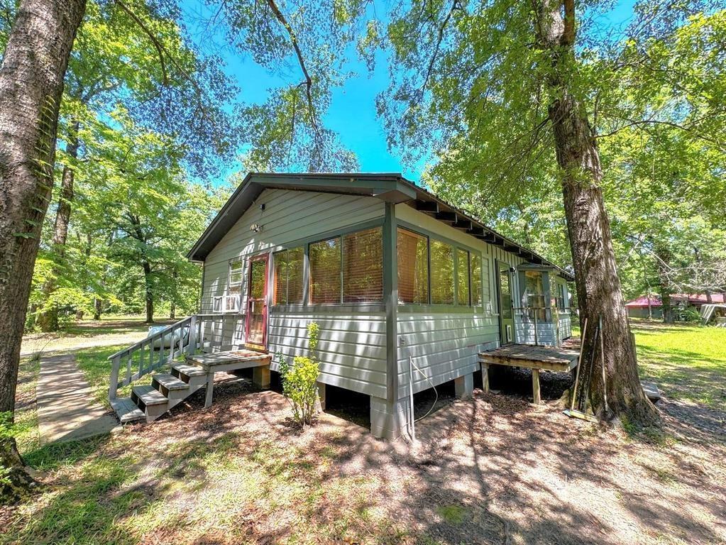 Image 0: View of property exterior featuring a sunroom and a wooden deck, Side Of Structure