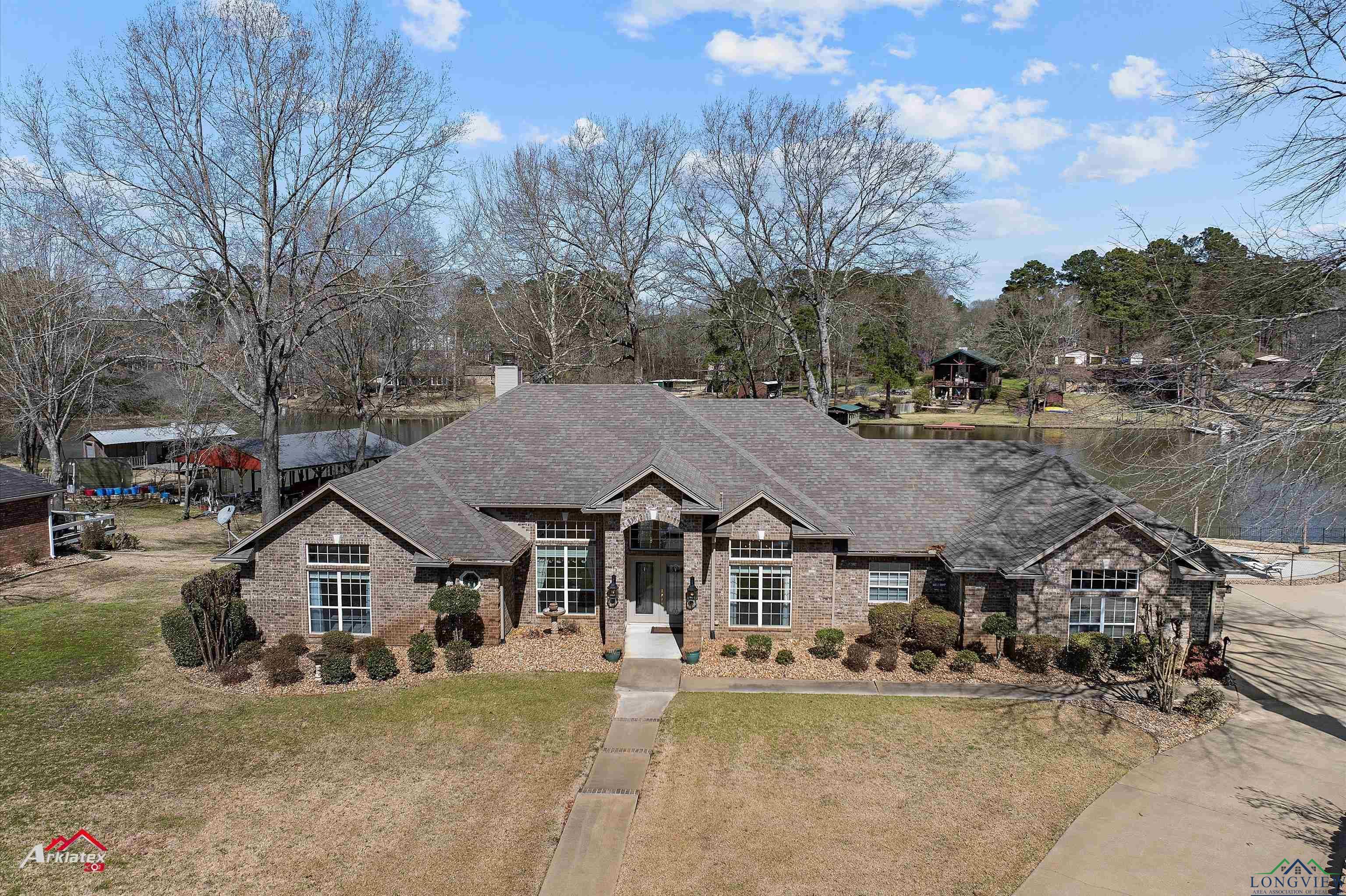 Image 0: French country home featuring brick siding, a chimney, a shingled roof, and a front yard, Front Of Structure