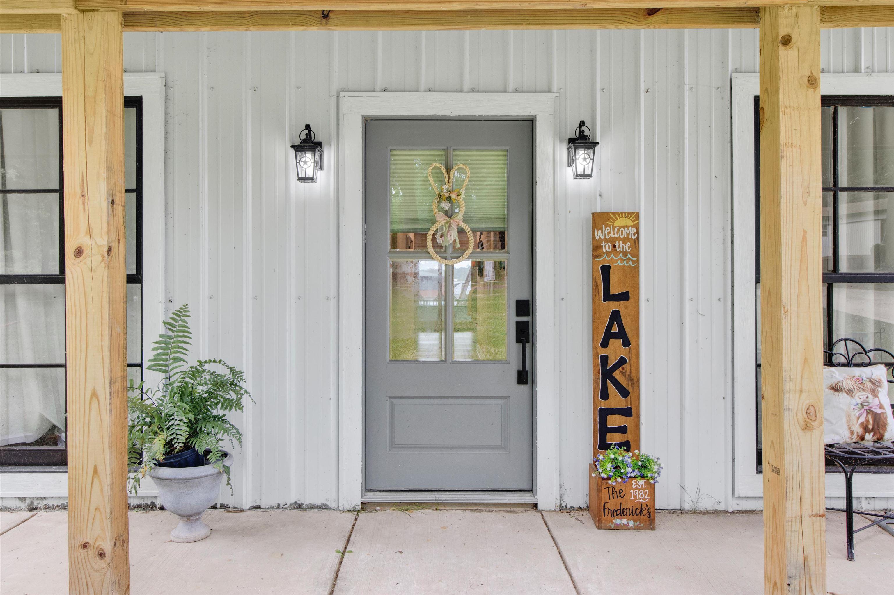 Image 0: Front entry with a gray door featuring a glass insert, flanked by two black lantern-style sconces, Entry