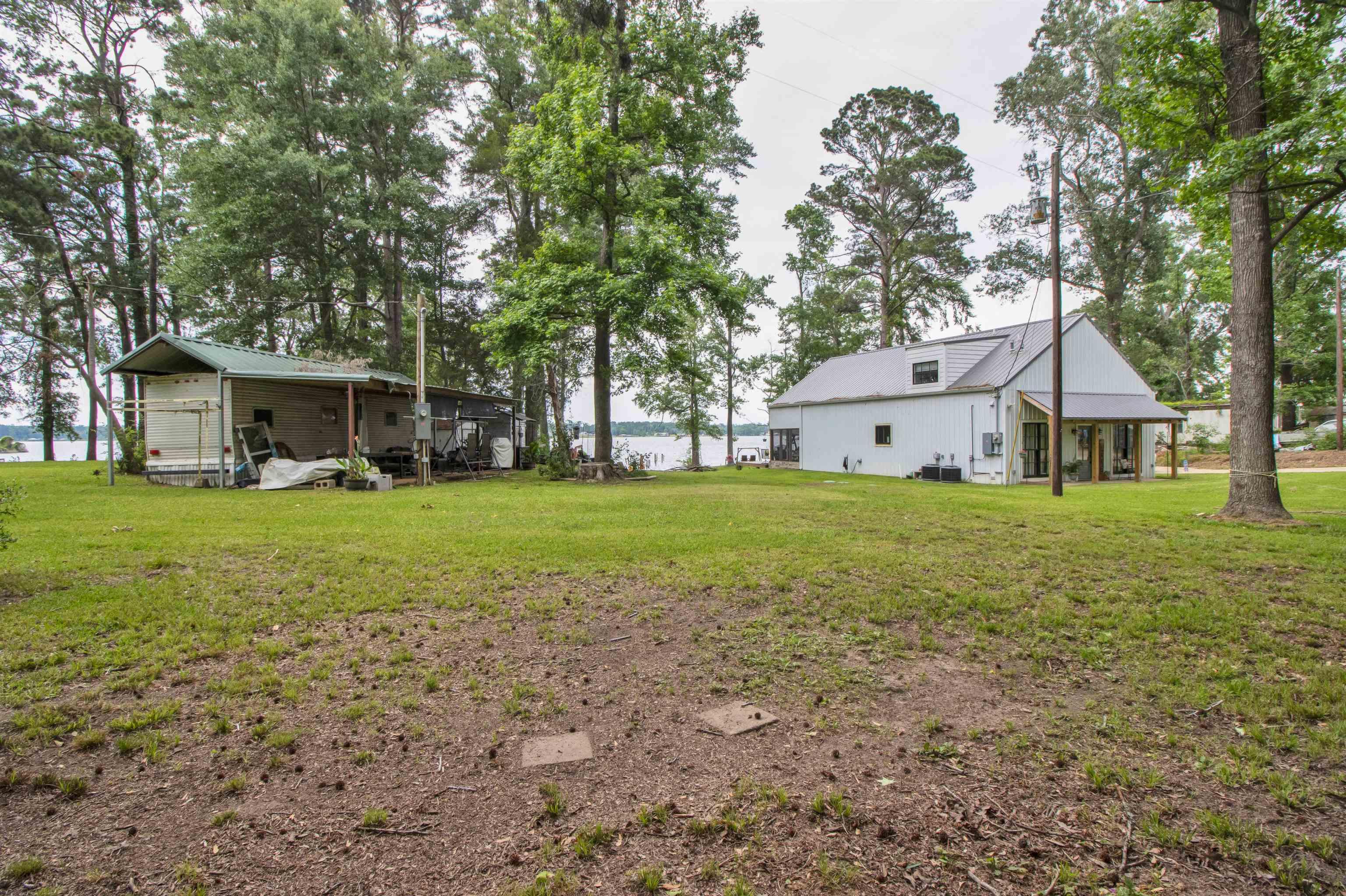 Image 3: Expansive grassy grounds with mature trees and waterfront access, Yard