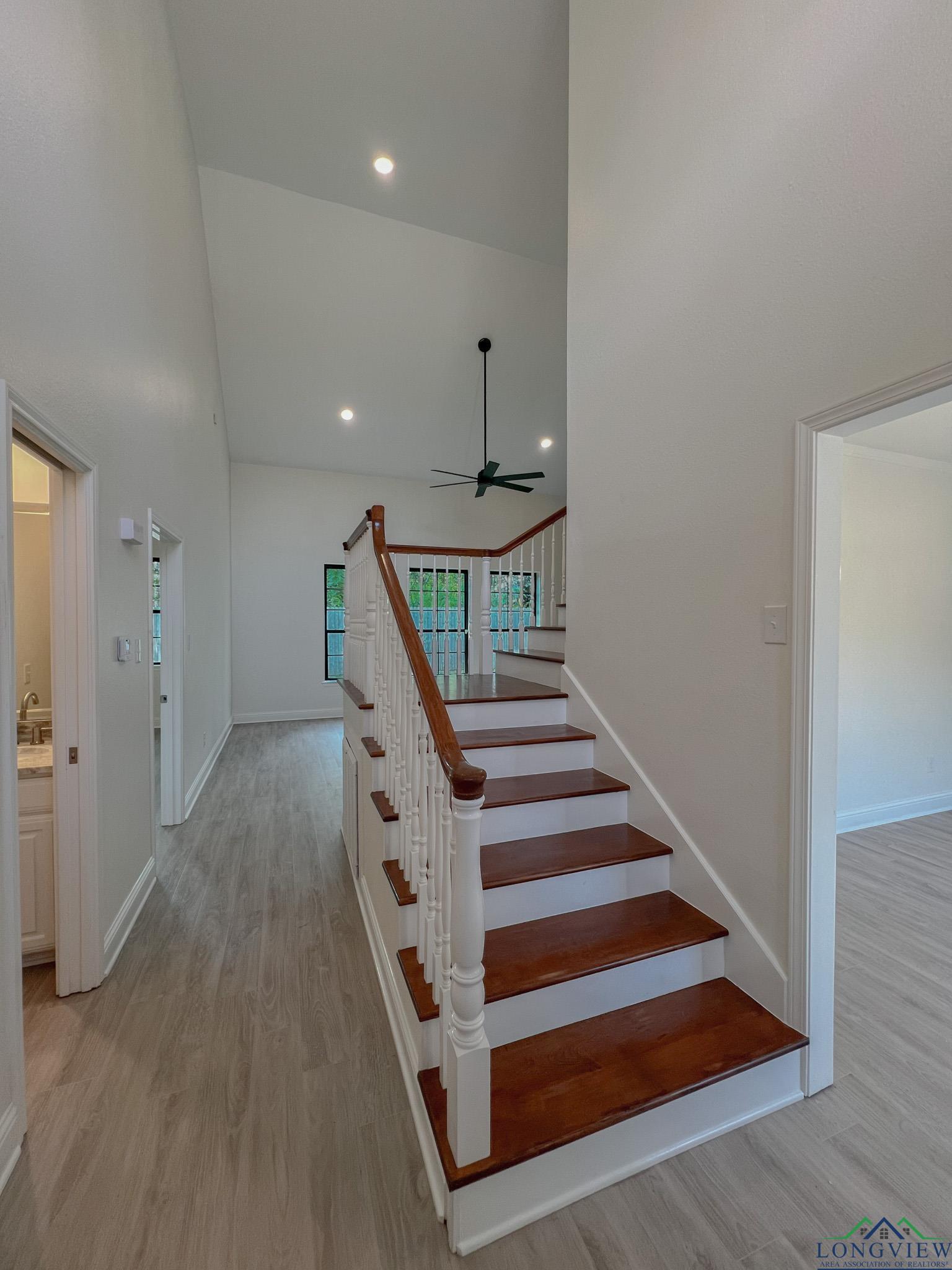 Image 2: Stairs with high vaulted ceiling, wood finished floors, recessed lighting, and ceiling fan, Stairs