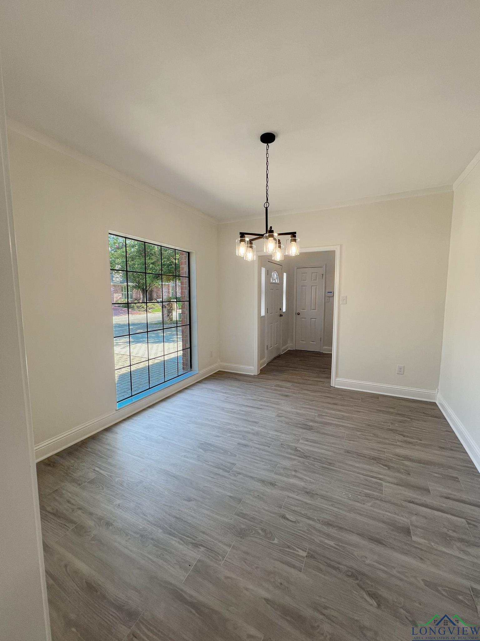 Image 3: Unfurnished dining area featuring wood finished floors, a chandelier, and ornamental molding, Dining Area
