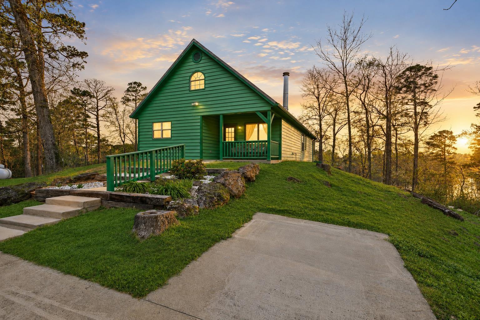 Image 0: Green siding exterior with a prominent gabled roofline and an arched window, Front Of Structure