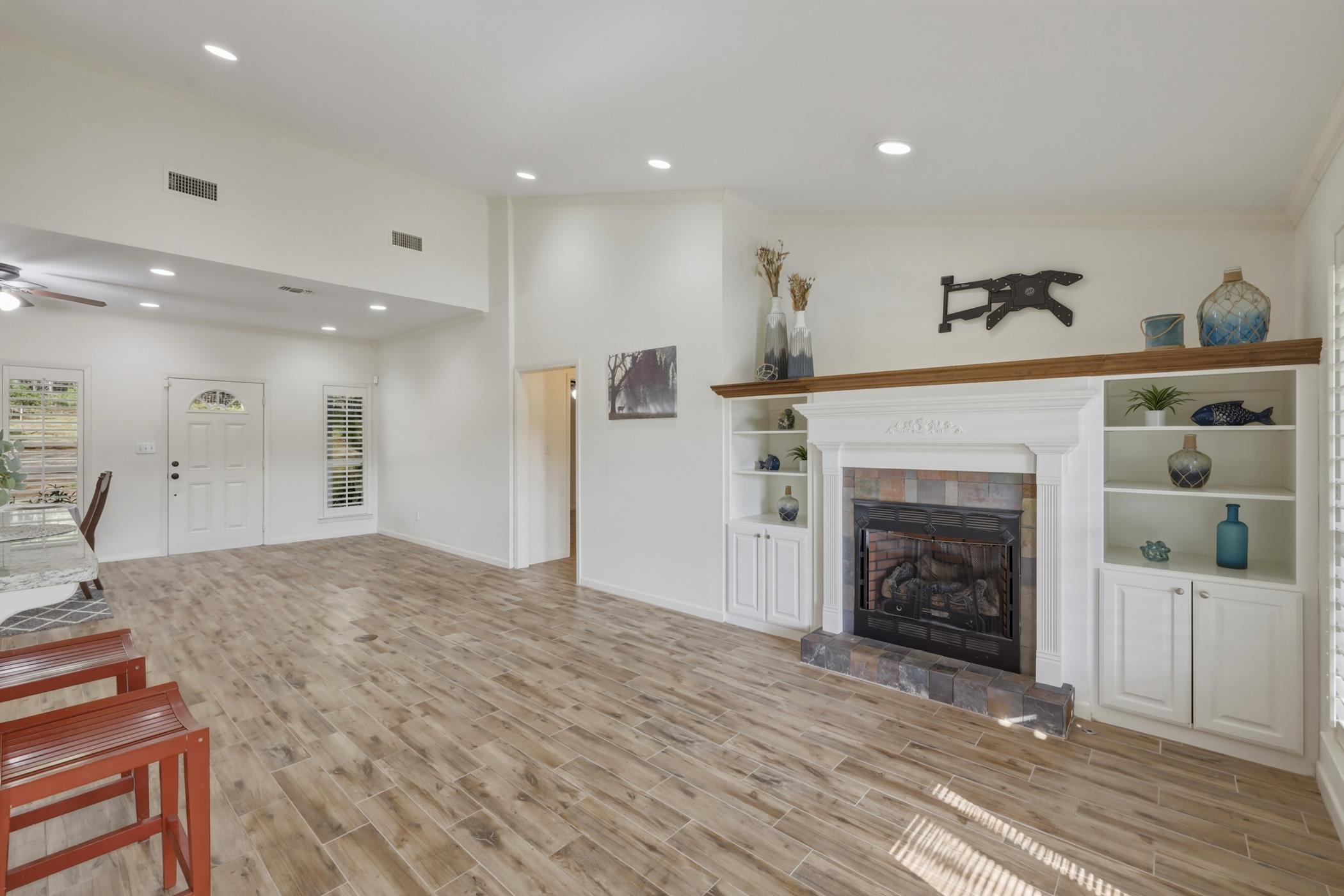 Image 2: Unfurnished living room with wood finish floors, recessed lighting, a ceiling fan, a tile fireplace, and vaulted ceiling, Living Room