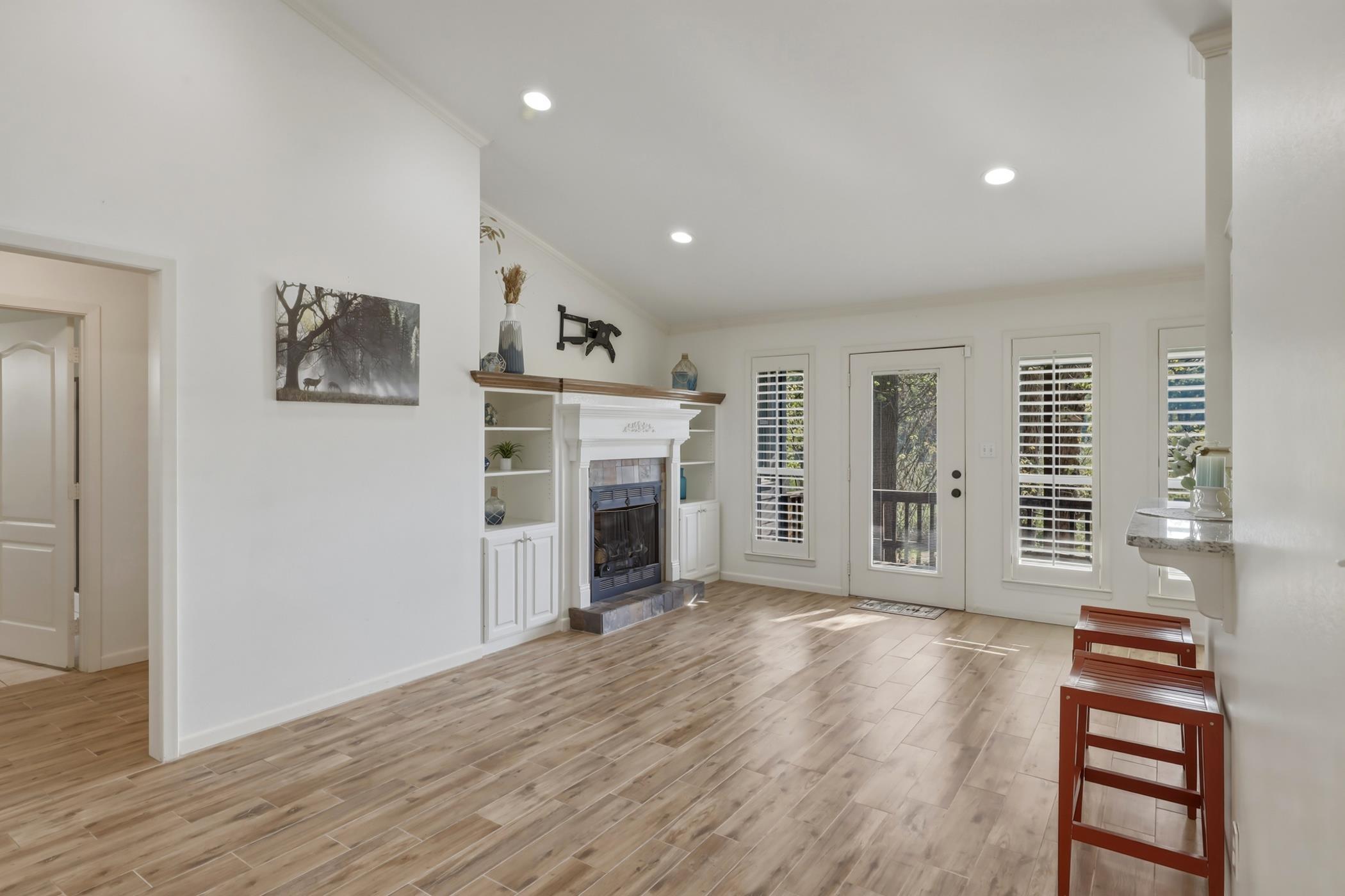 Image 3: Unfurnished living room featuring lofted ceiling, light wood-type flooring, recessed lighting, ornamental molding, and a fireplace, Living Room
