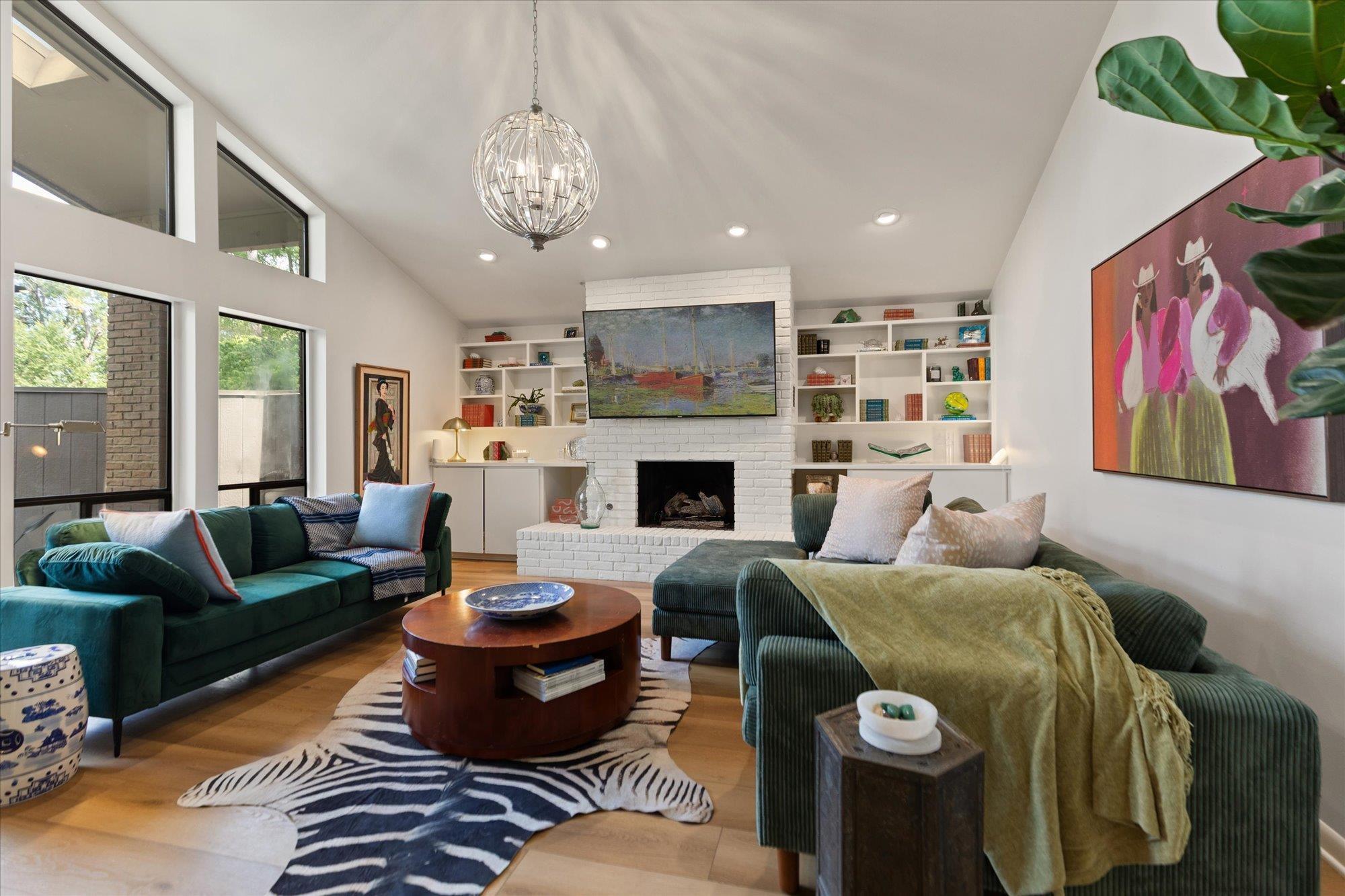 Image 3: Spacious living area featuring a vaulted ceiling and a contemporary chandelier, Living Room