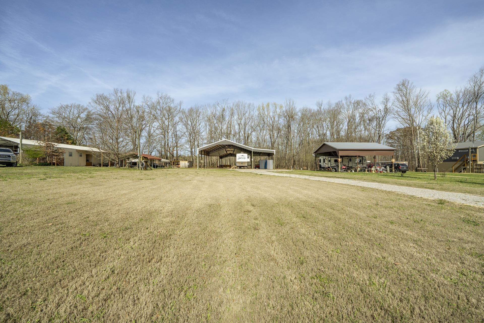 Image 2: View of green lawn with a detached carport
