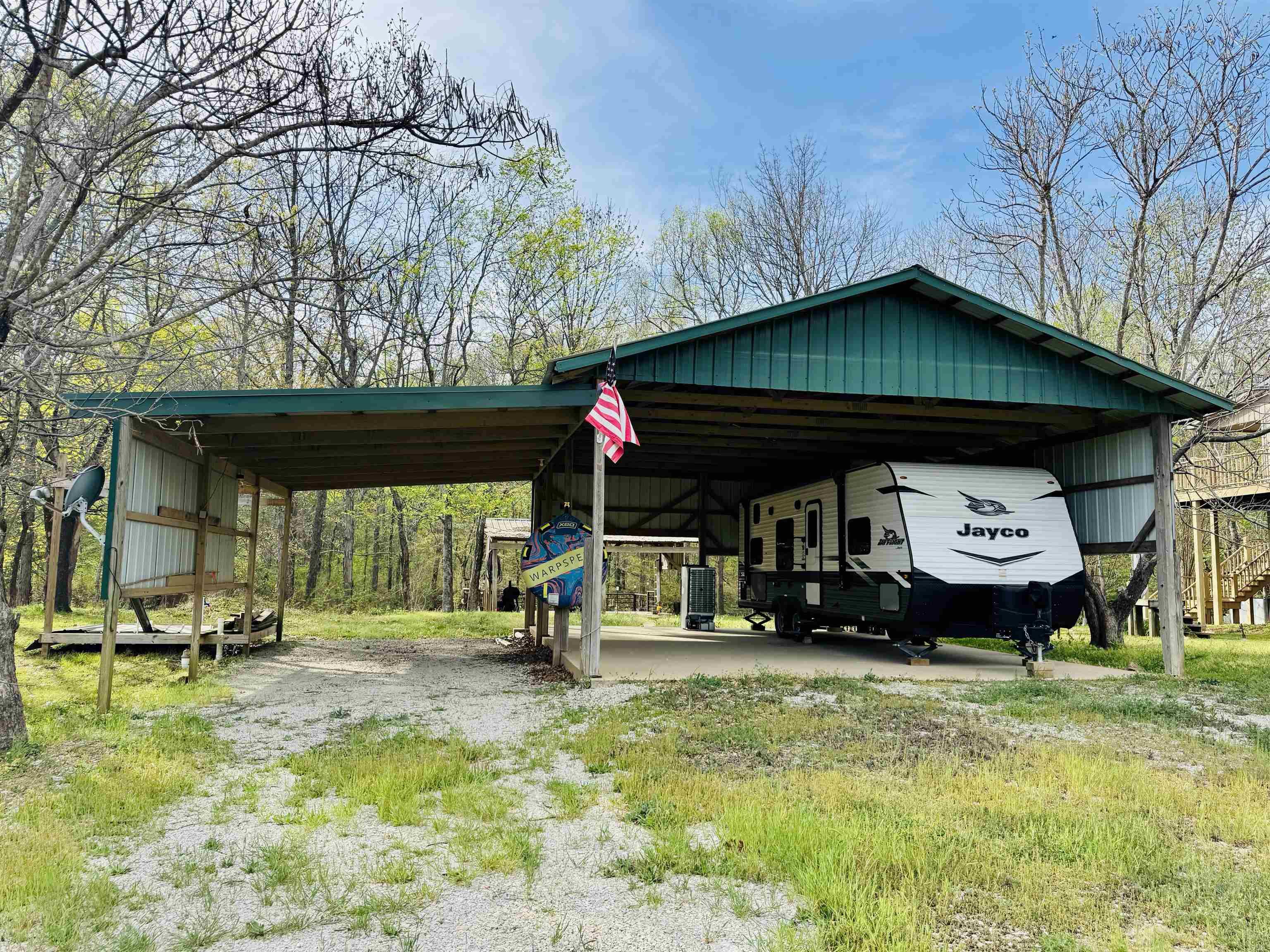 Image 2: View of parking for more than one RV. There is a 30 ft wide driveway to help ease maneuvering your RV into the covered area.