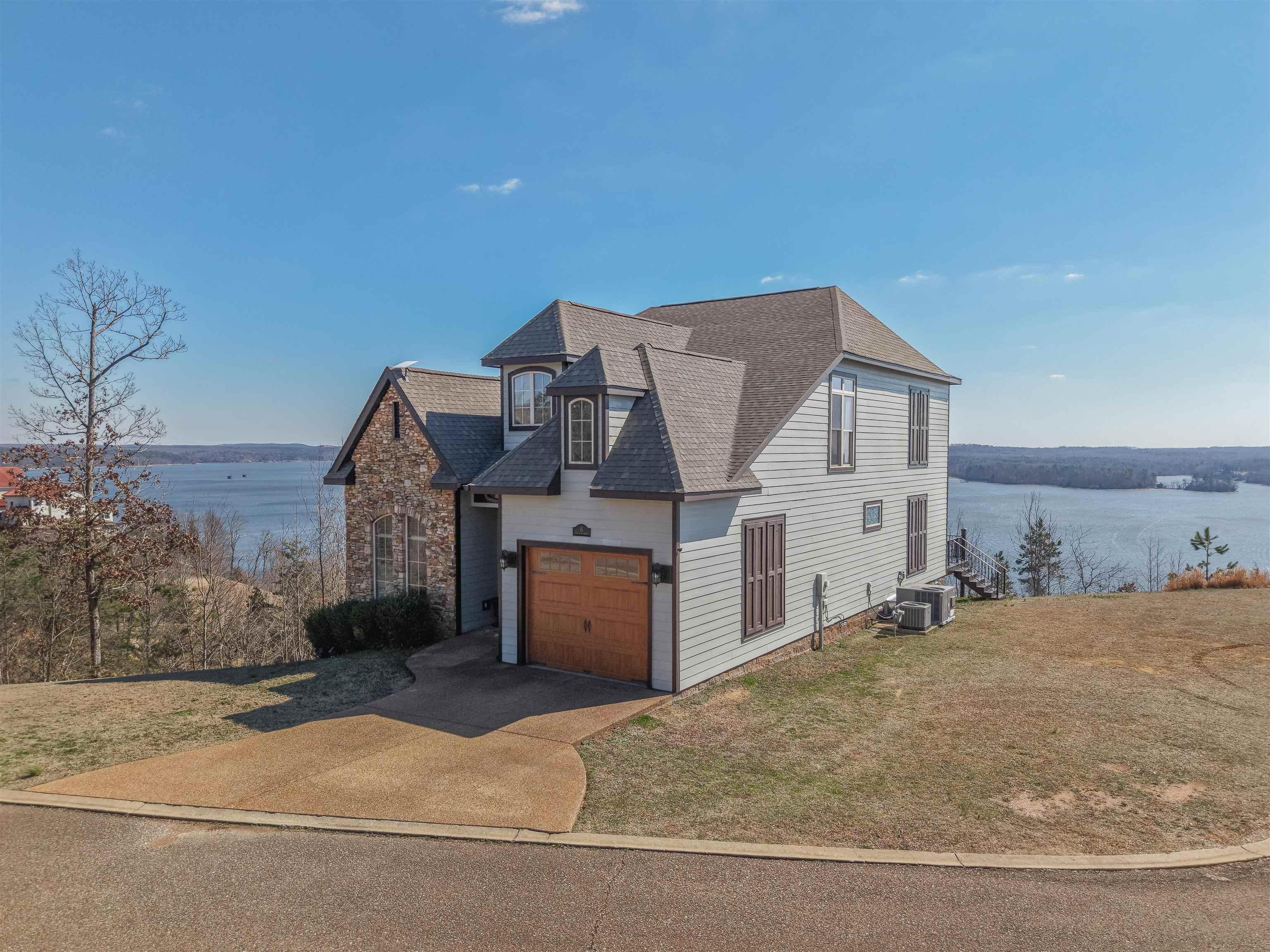 Image 2: Two-story residence featuring a stone and siding exterior with a prominent multi-gable roofline