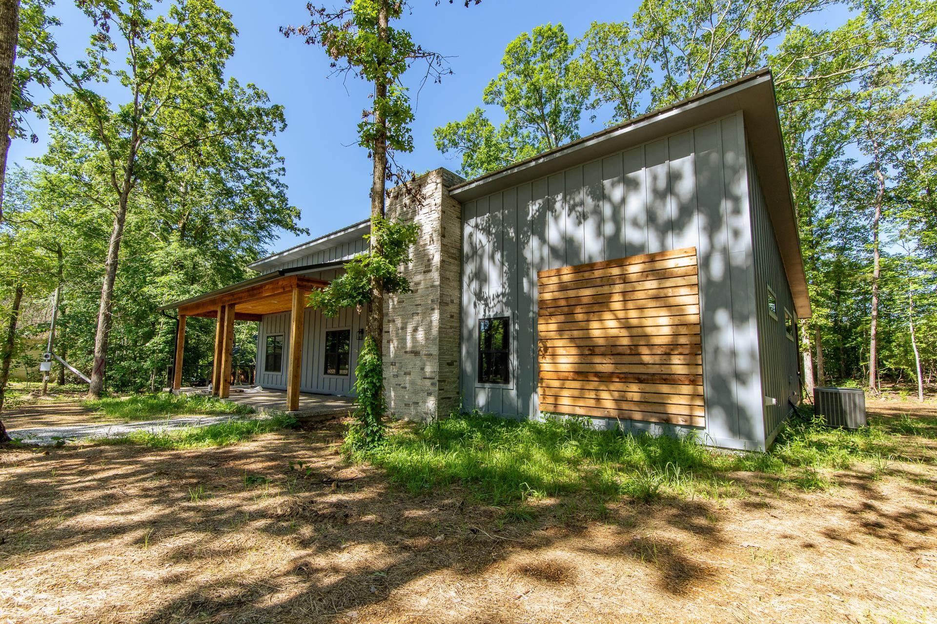 Image 4: Rear view of property with board and batten siding and a chimney