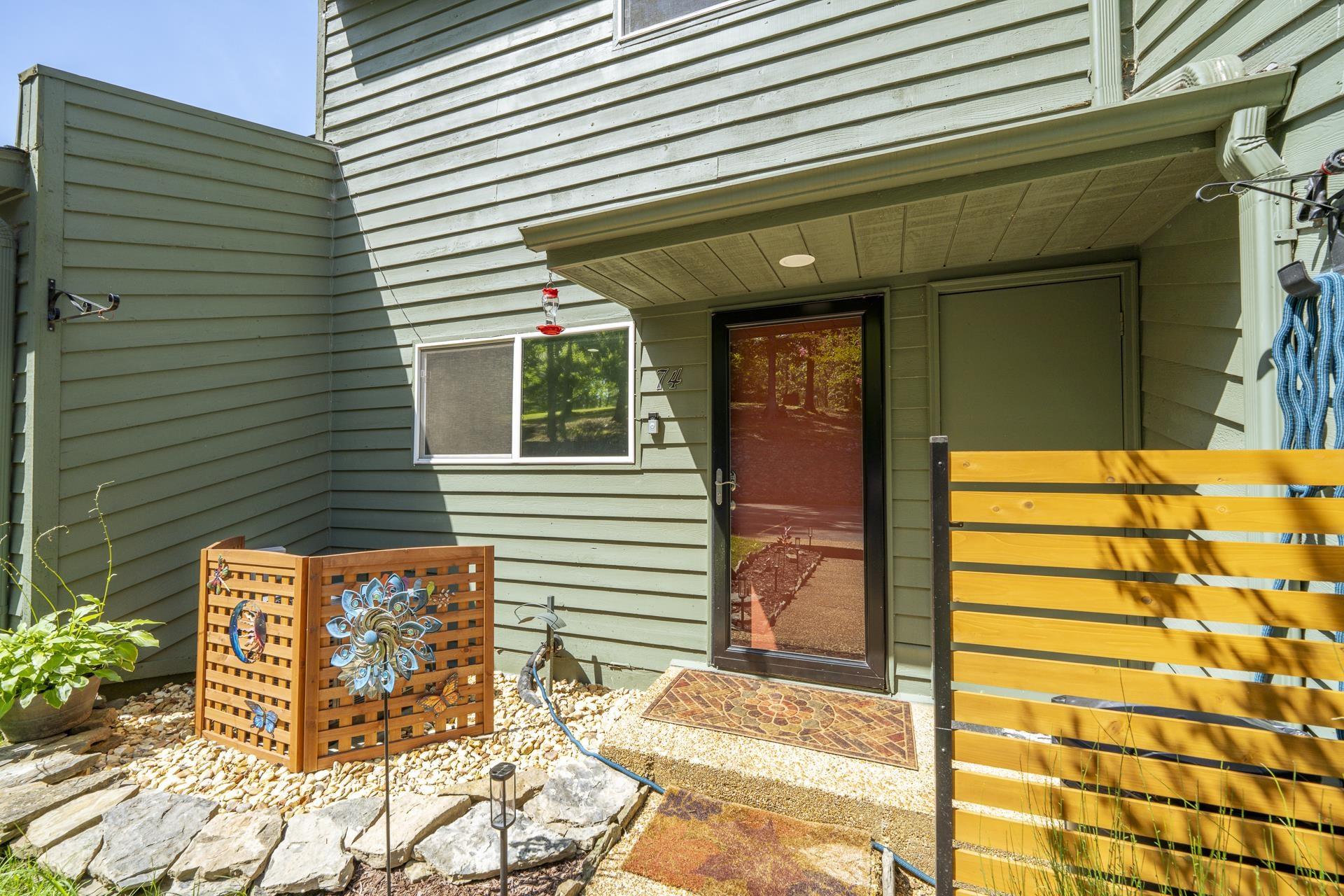 Image 4: Entryway featuring a black-framed screen door, light green siding, and a slatted wooden privacy fence
