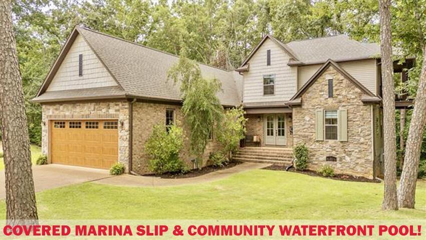 Image 1: Stone and siding exterior with a two-car garage featuring a wood-finish door and window inserts