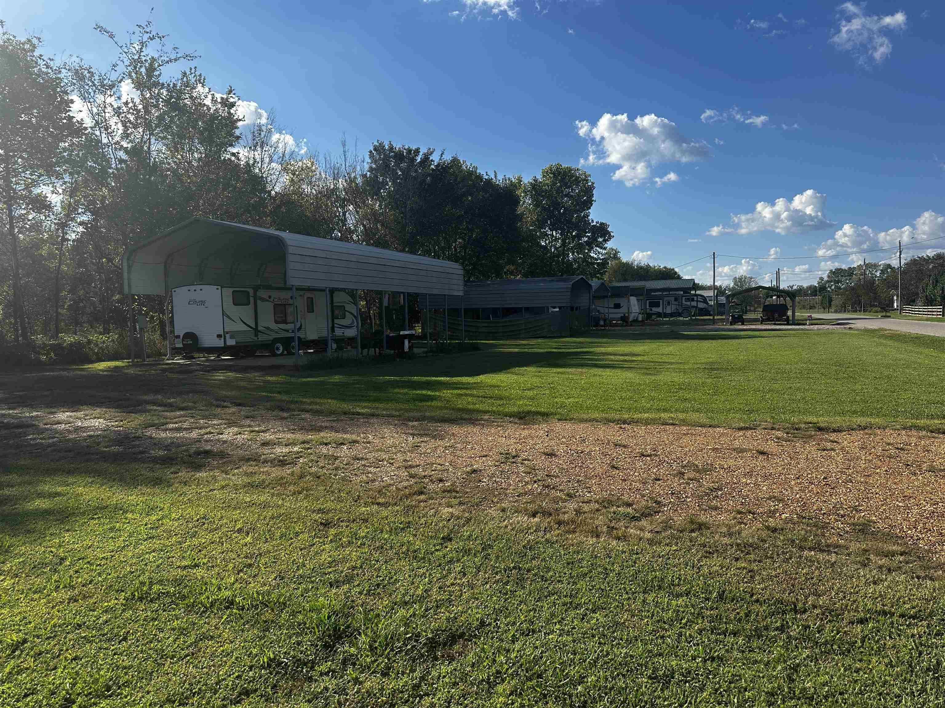 Image 2: View of grassy yard featuring a carport