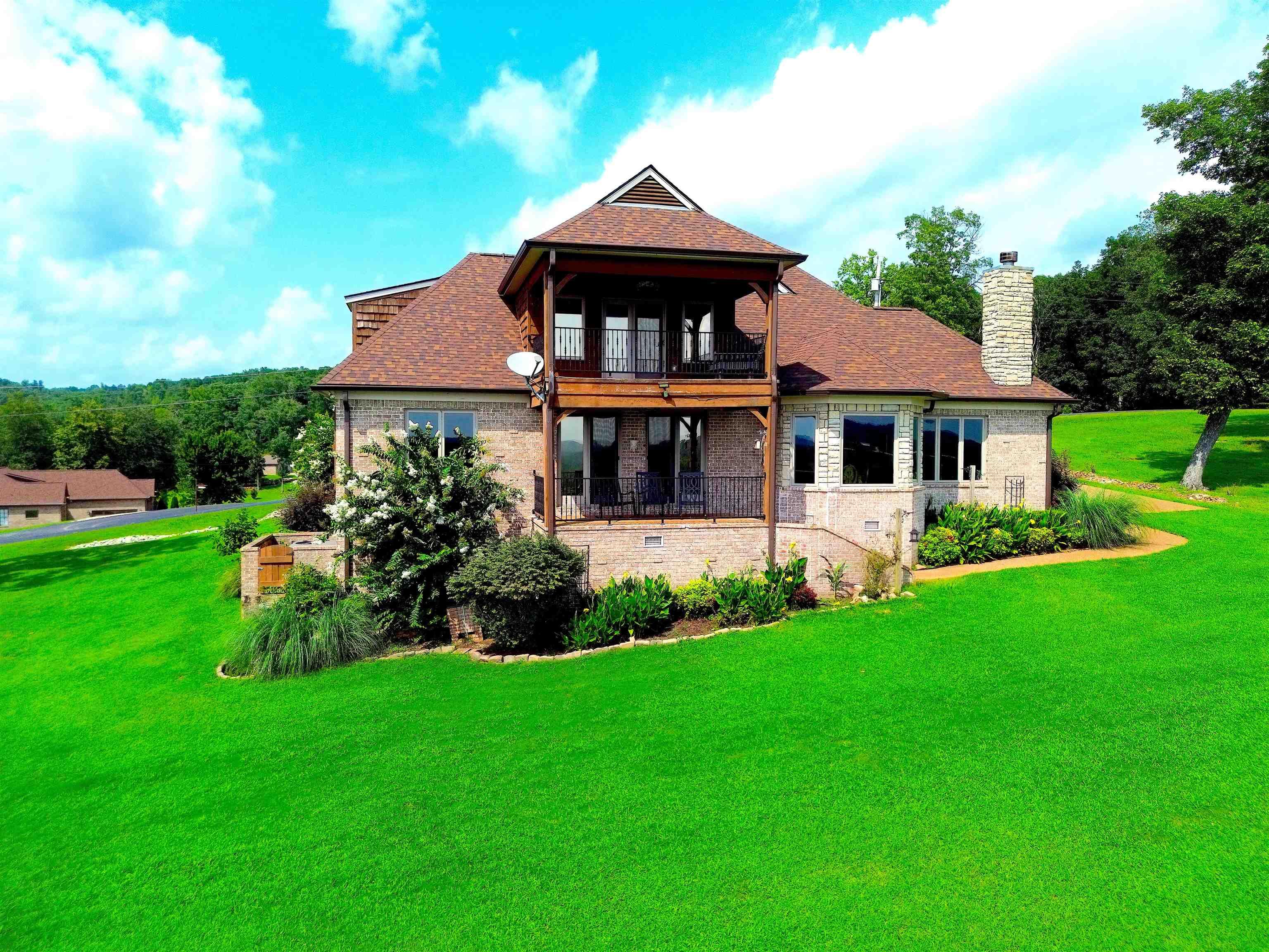 Image 2: Two-story residence featuring a brick exterior with a prominent stone chimney