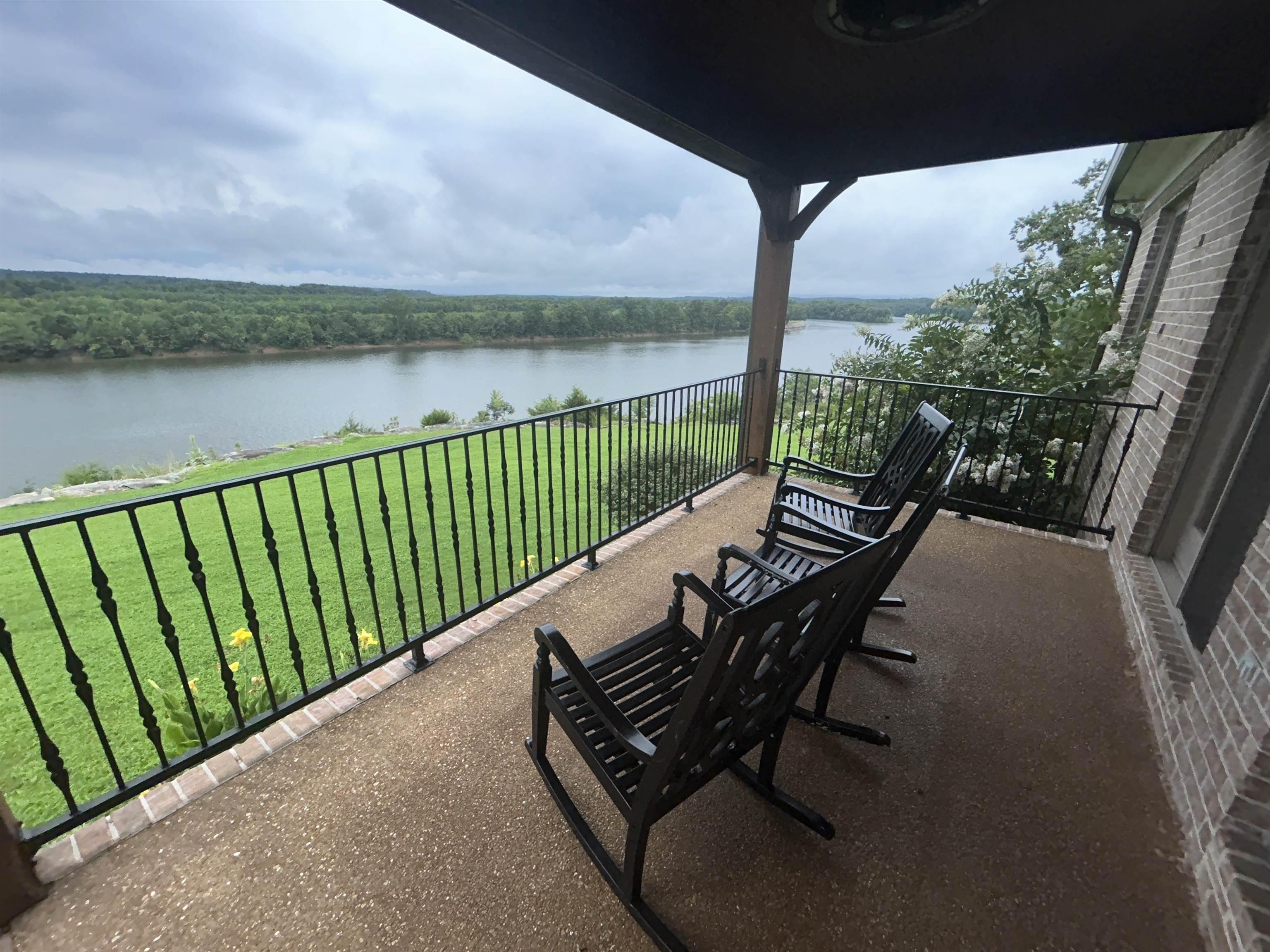Image 3: Covered patio with textured concrete flooring and black wrought iron railing