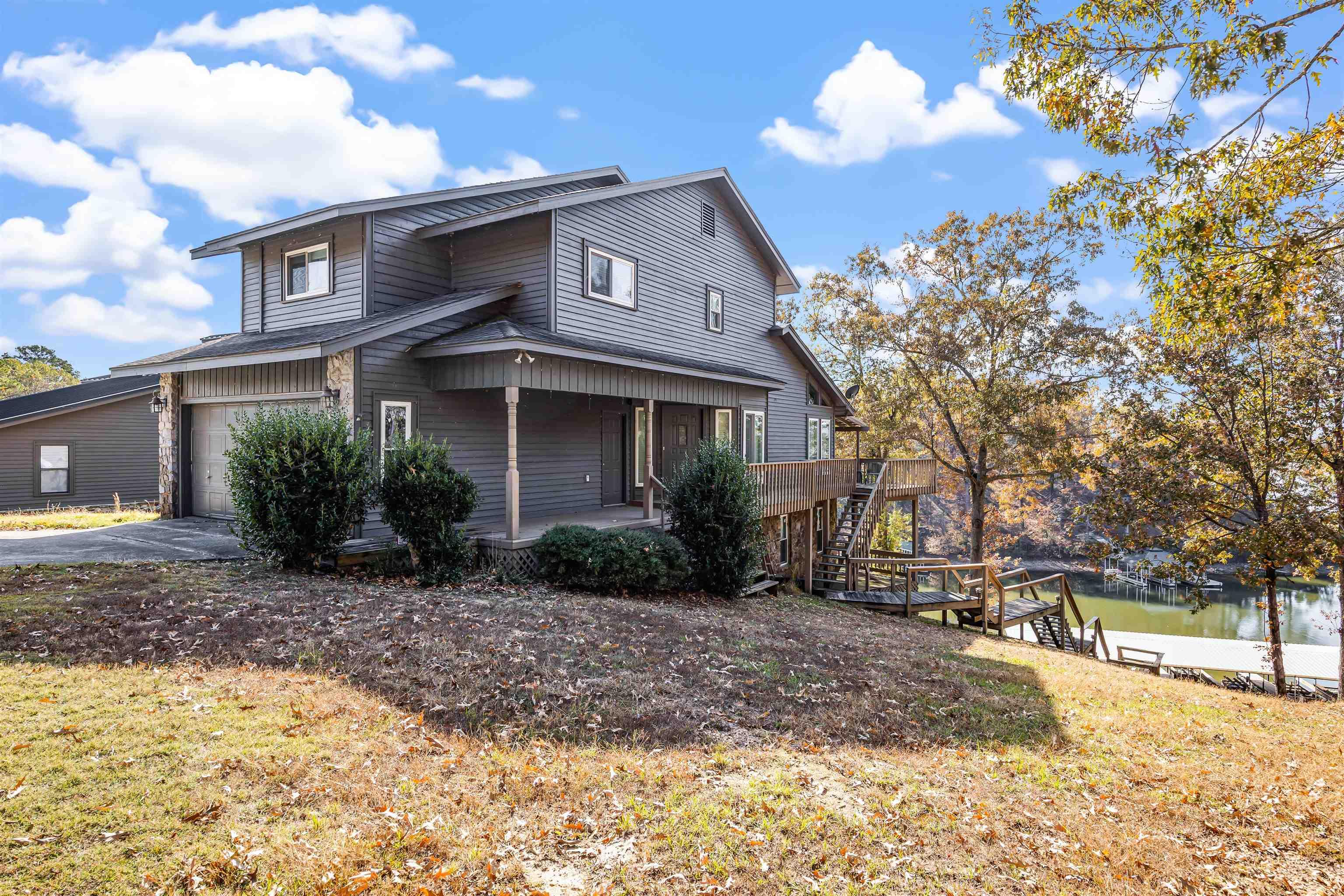 Image 2: View of front of house featuring stairs, driveway, a front yard, and an attached garage
