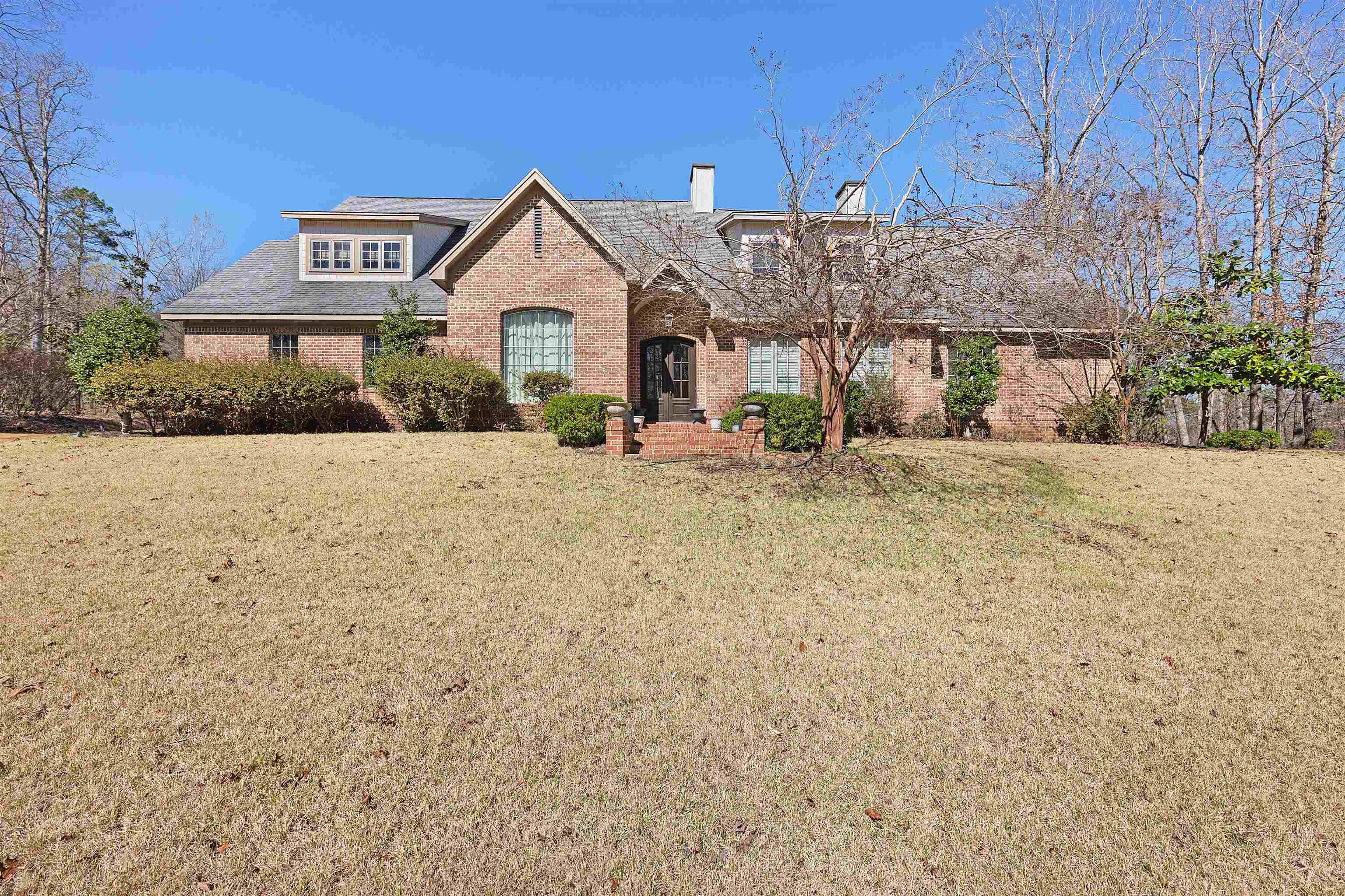 Image 2: View of front facade featuring brick siding, a front yard, and a chimney