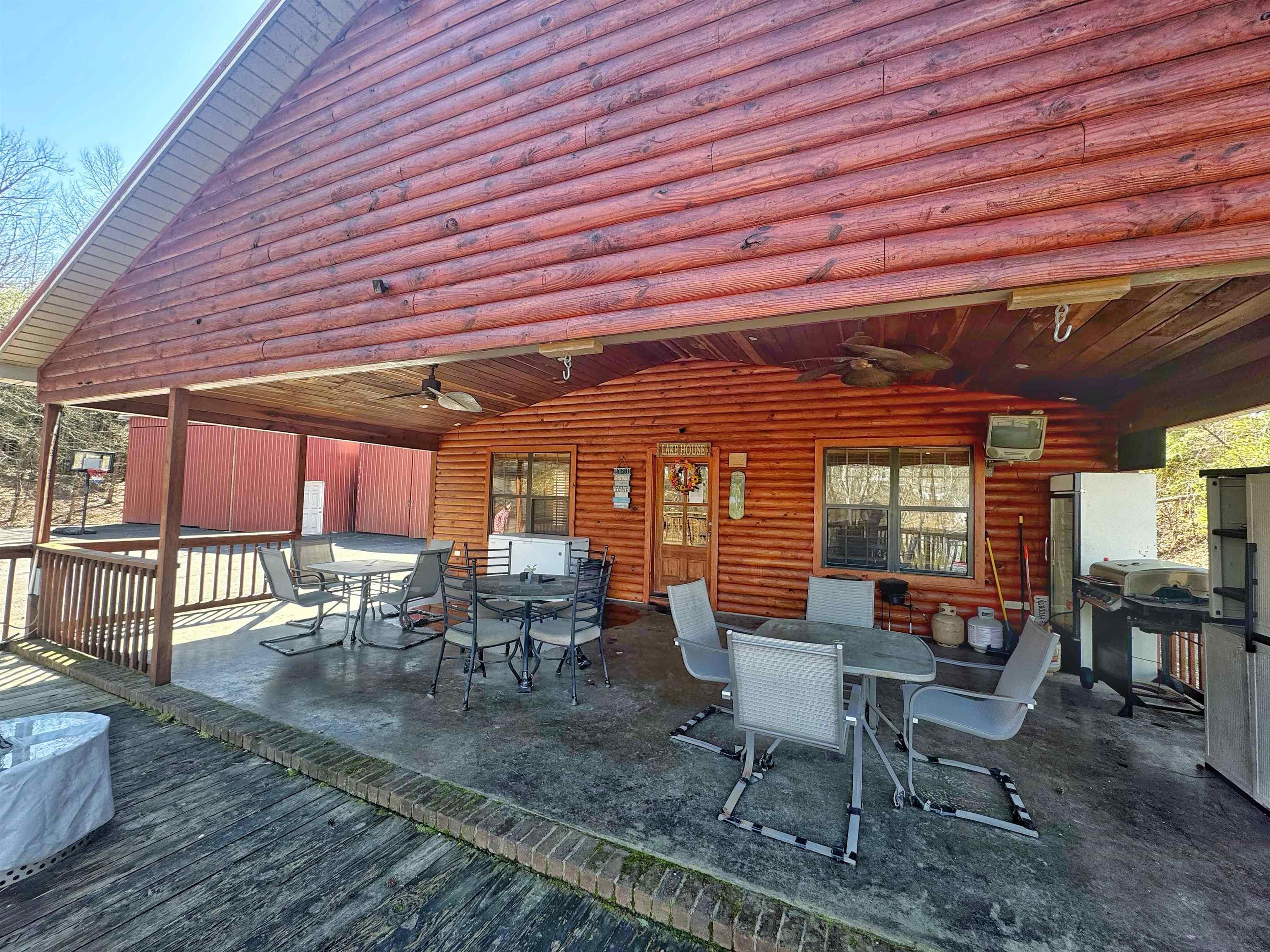 Image 3: Wooden terrace with outdoor dining area, a ceiling fan, a patio, and a grill