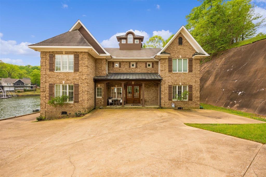 Image 2: Brick exterior residence featuring multiple gables and a waterside location