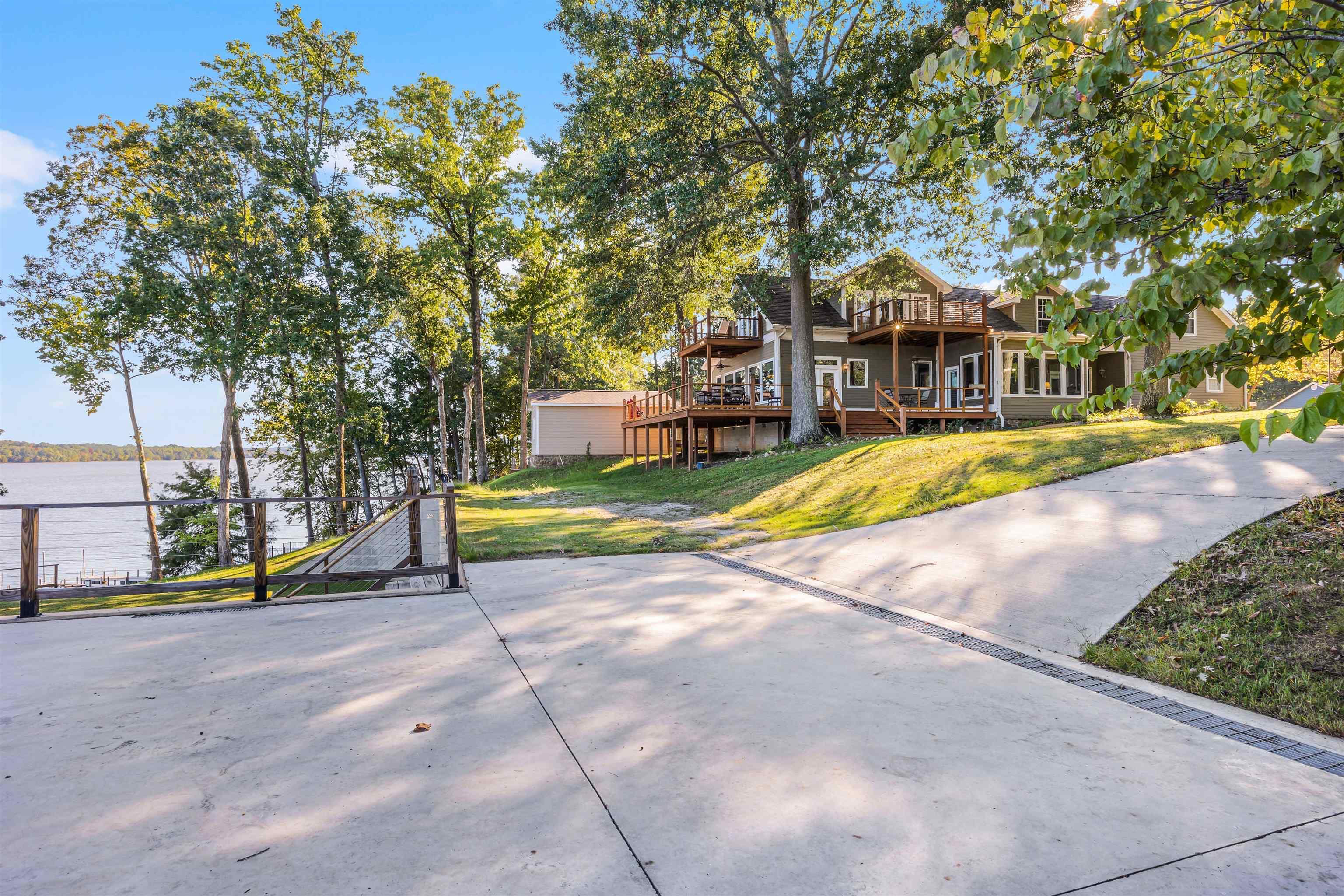 Image 1: View of front facade with a deck with water view and a front yard