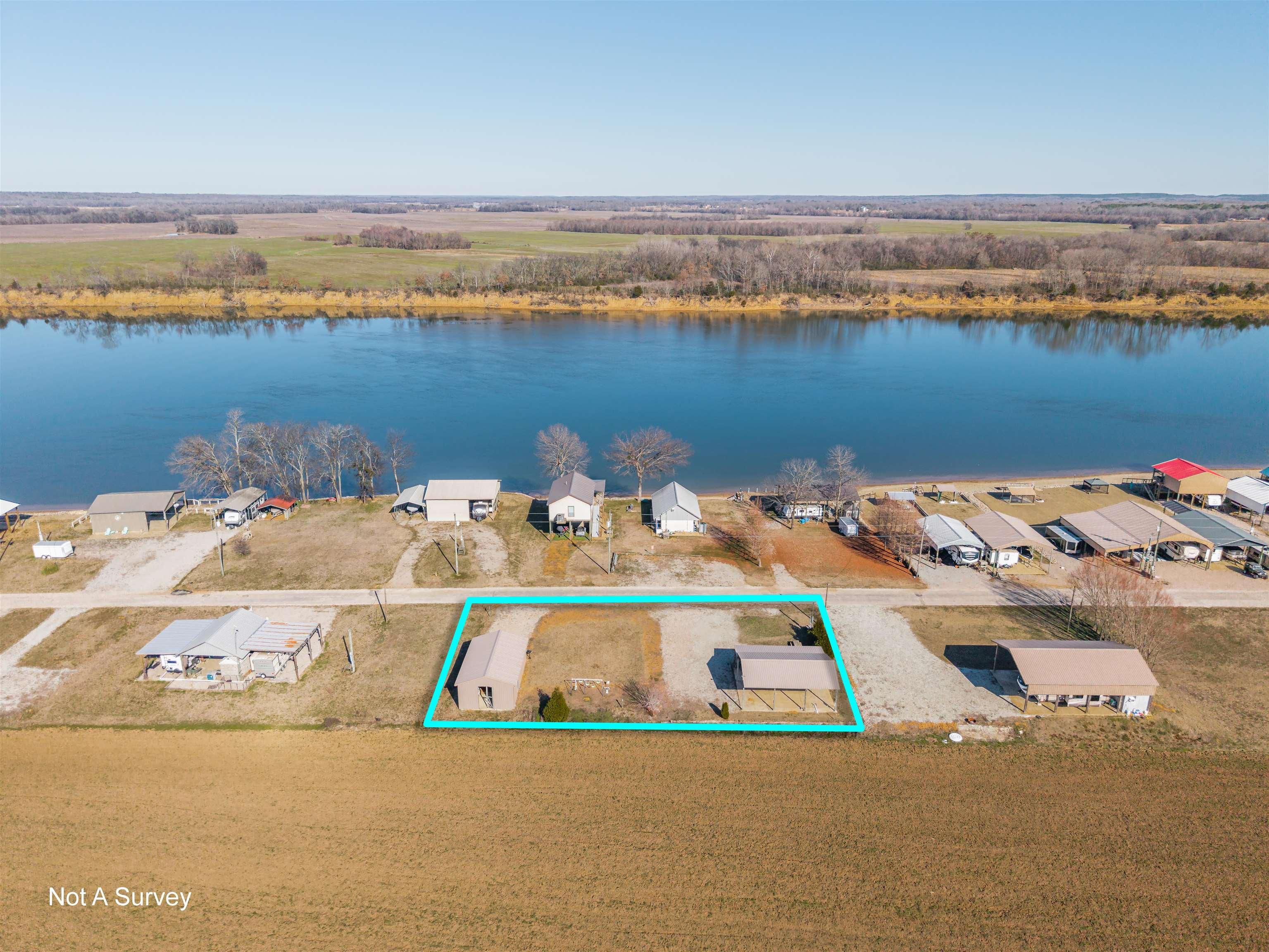 Image 1: Aerial perspective of suburban area featuring a large body of water and property boundaries highlighted