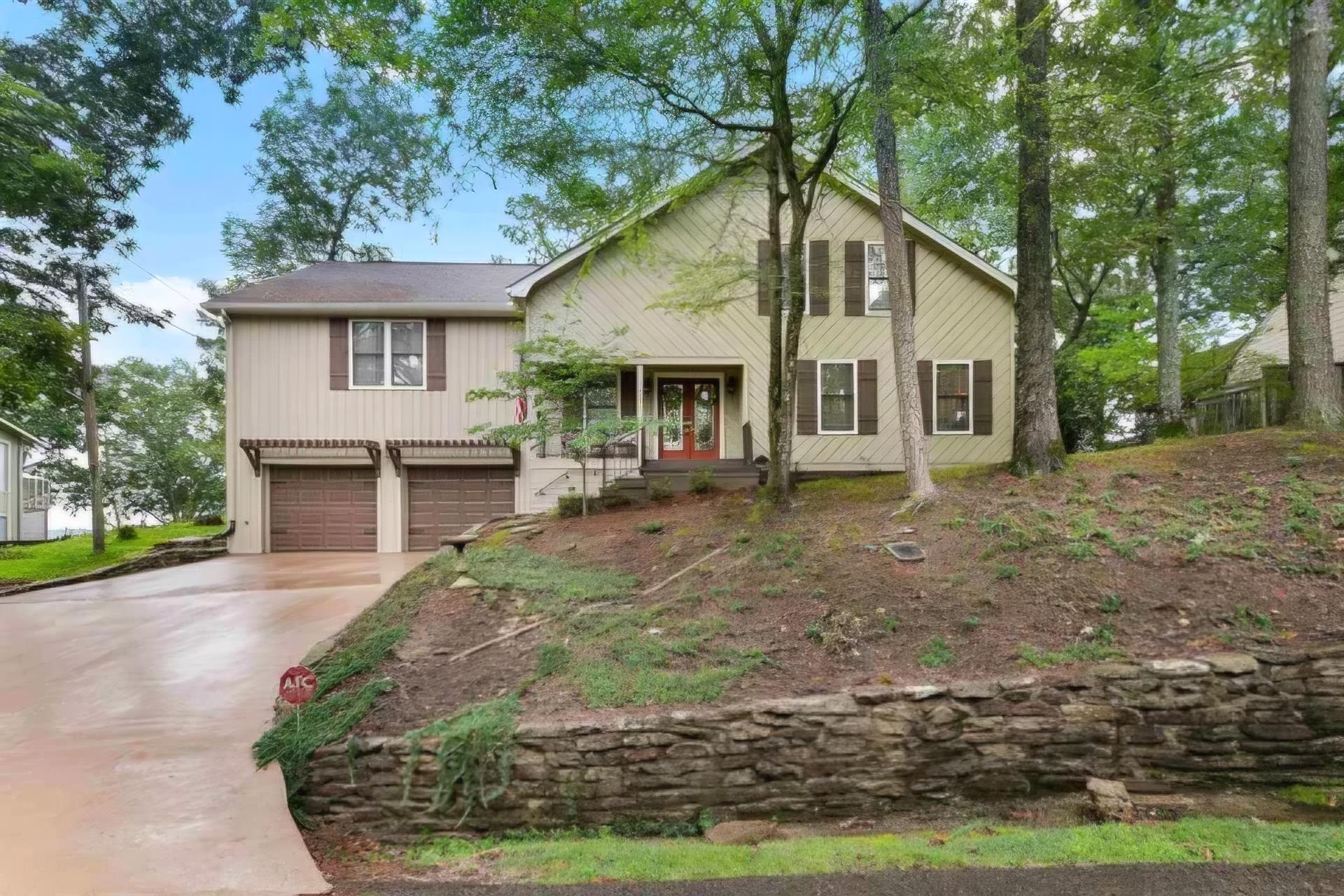 Image 1: View of front of home featuring an attached garage, concrete driveway, and french doors