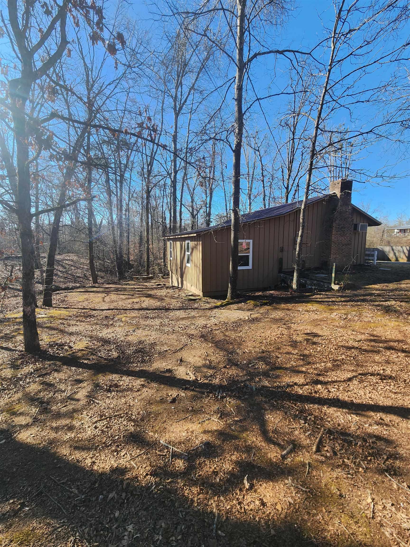 Image 2: View of home's exterior featuring a chimney and board and batten siding