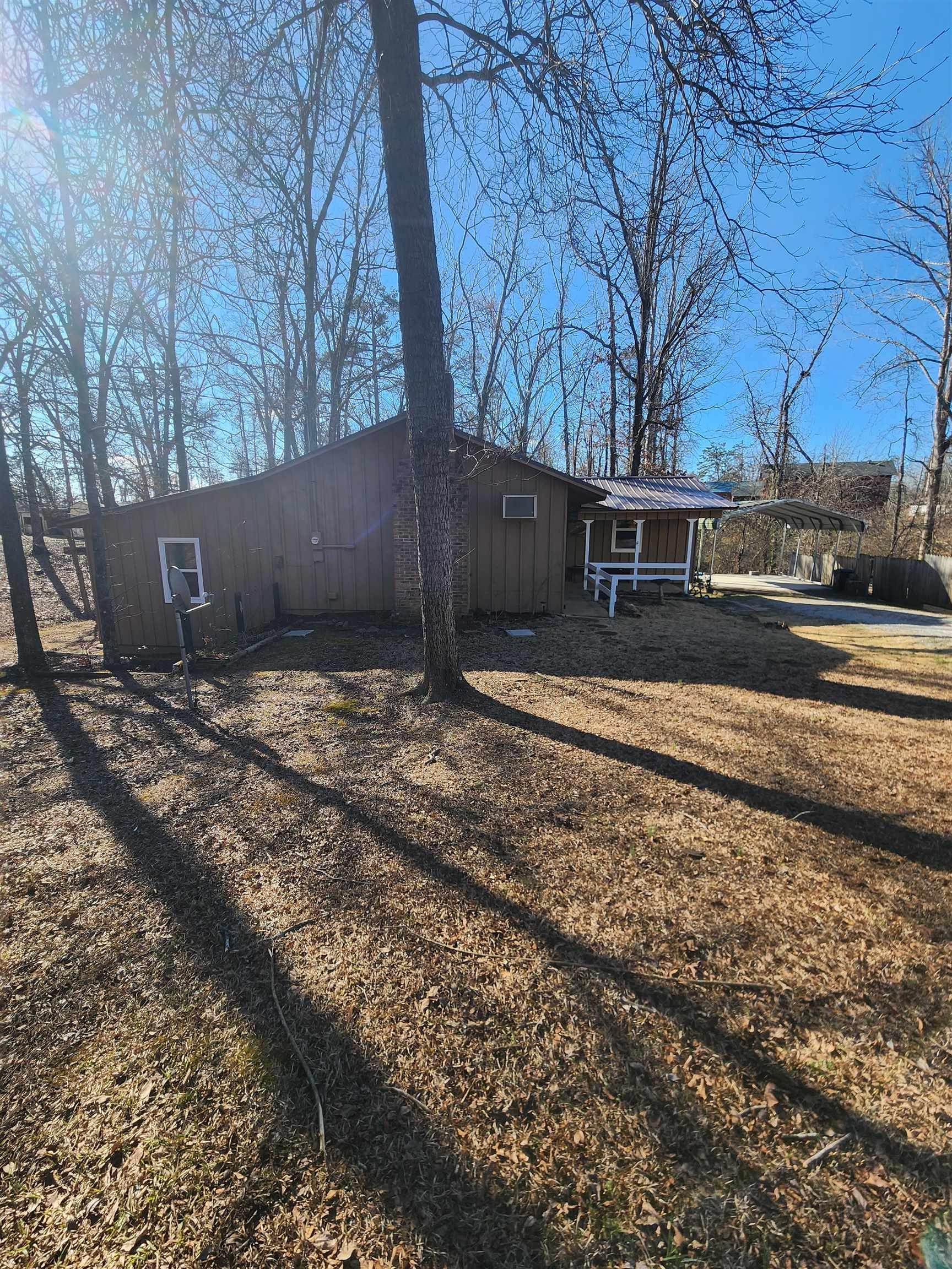 Image 3: View of front of house featuring a detached carport and board and batten siding