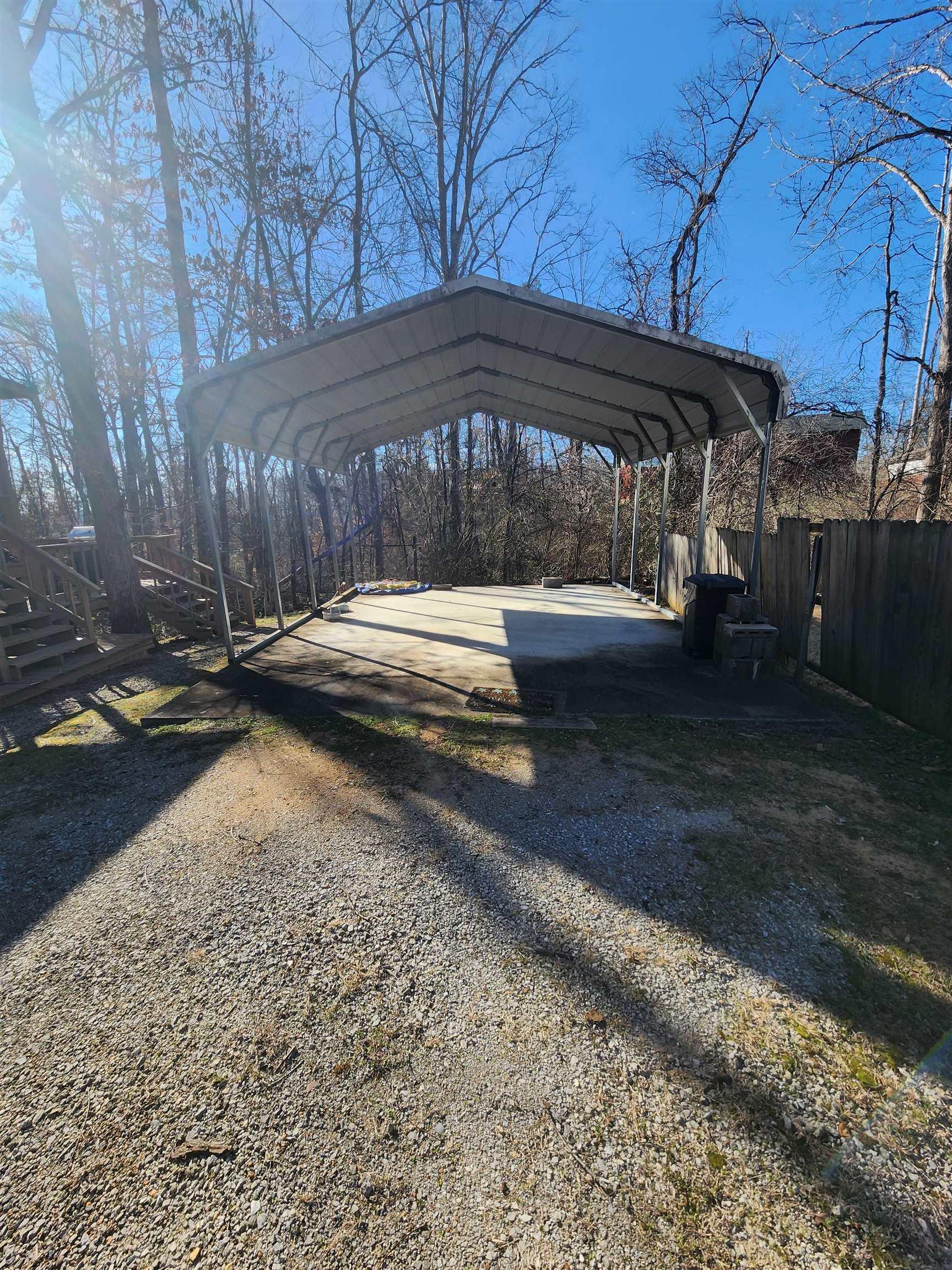 Image 4: View of parking with a detached carport and driveway
