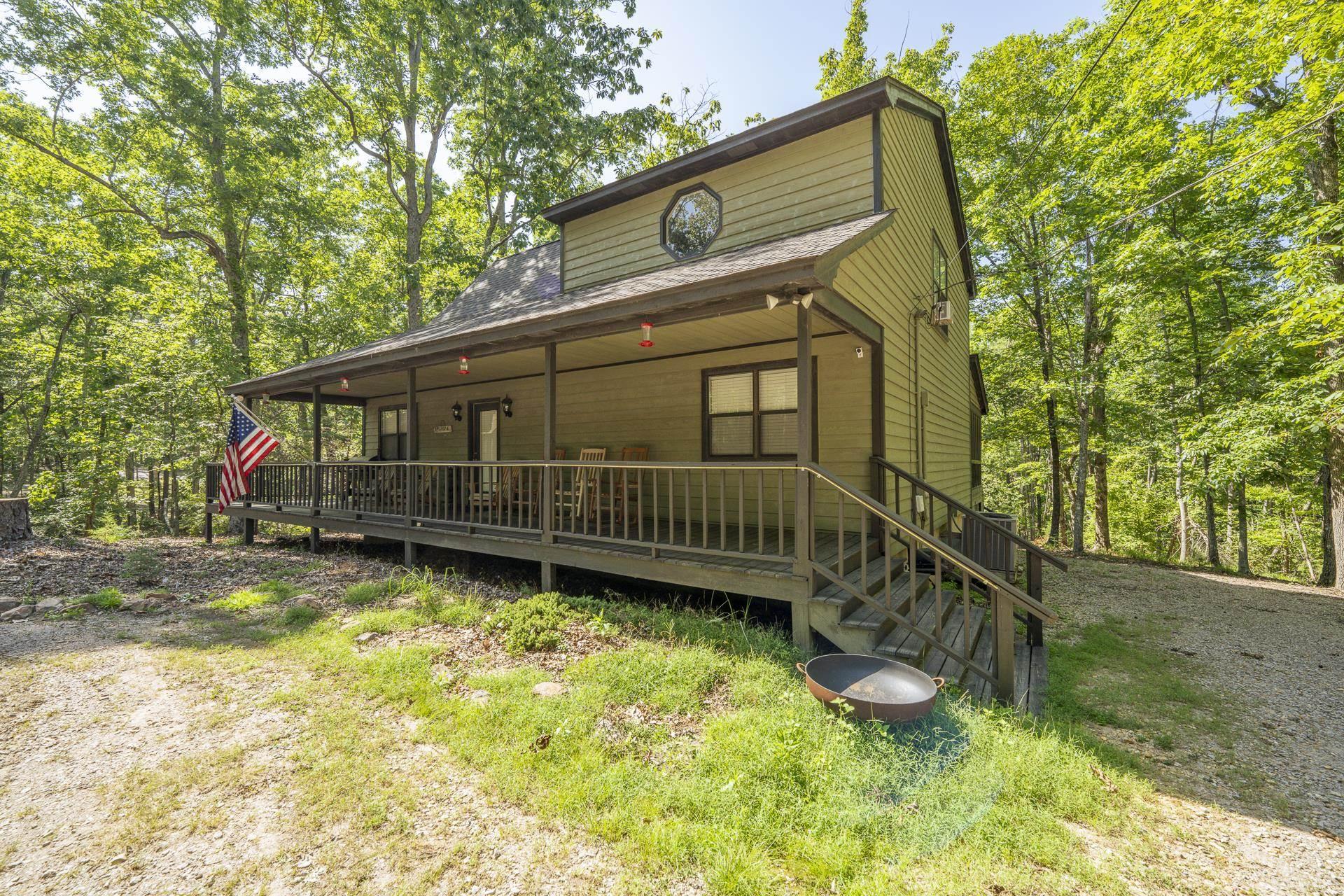 Image 3: Cabin-style residence featuring a wrap-around porch and elevated entry with stairs