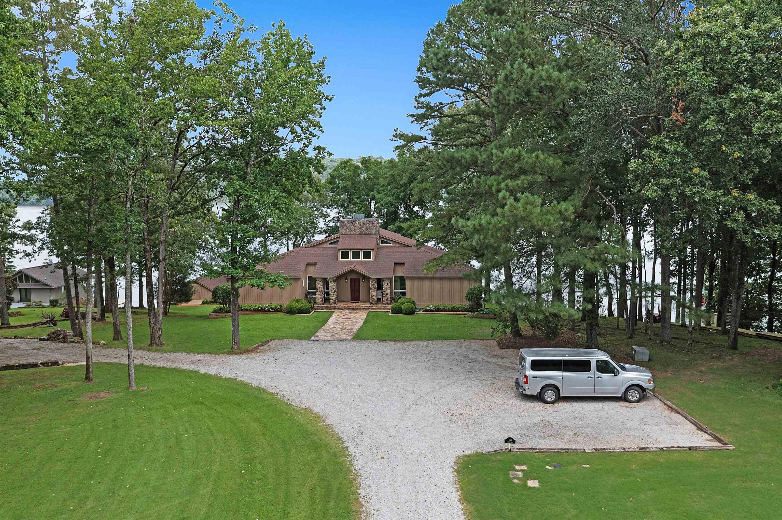 Image 2: Mid-century home with stucco siding, a front yard, and driveway