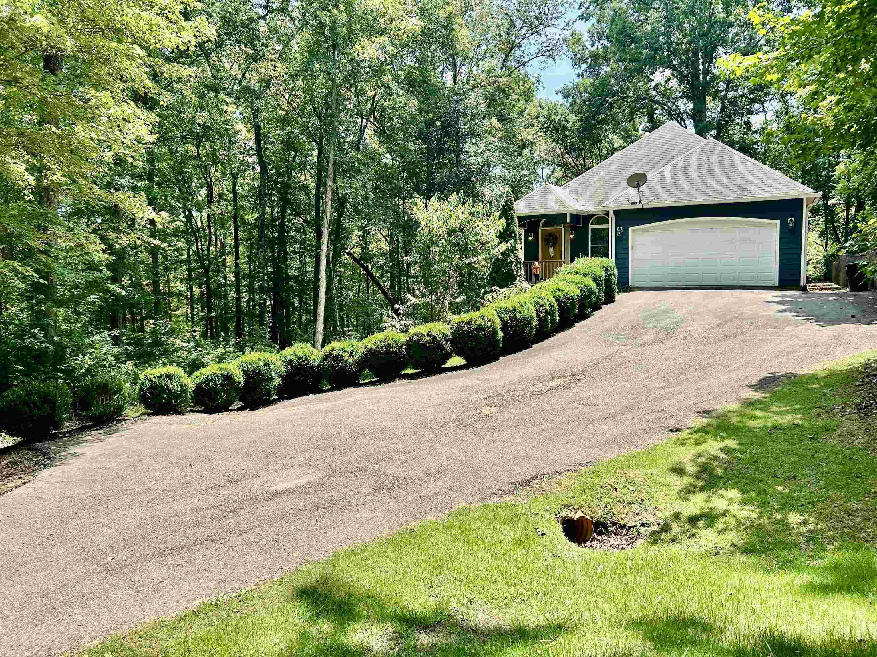 Image 2: View of front of property featuring driveway and a garage