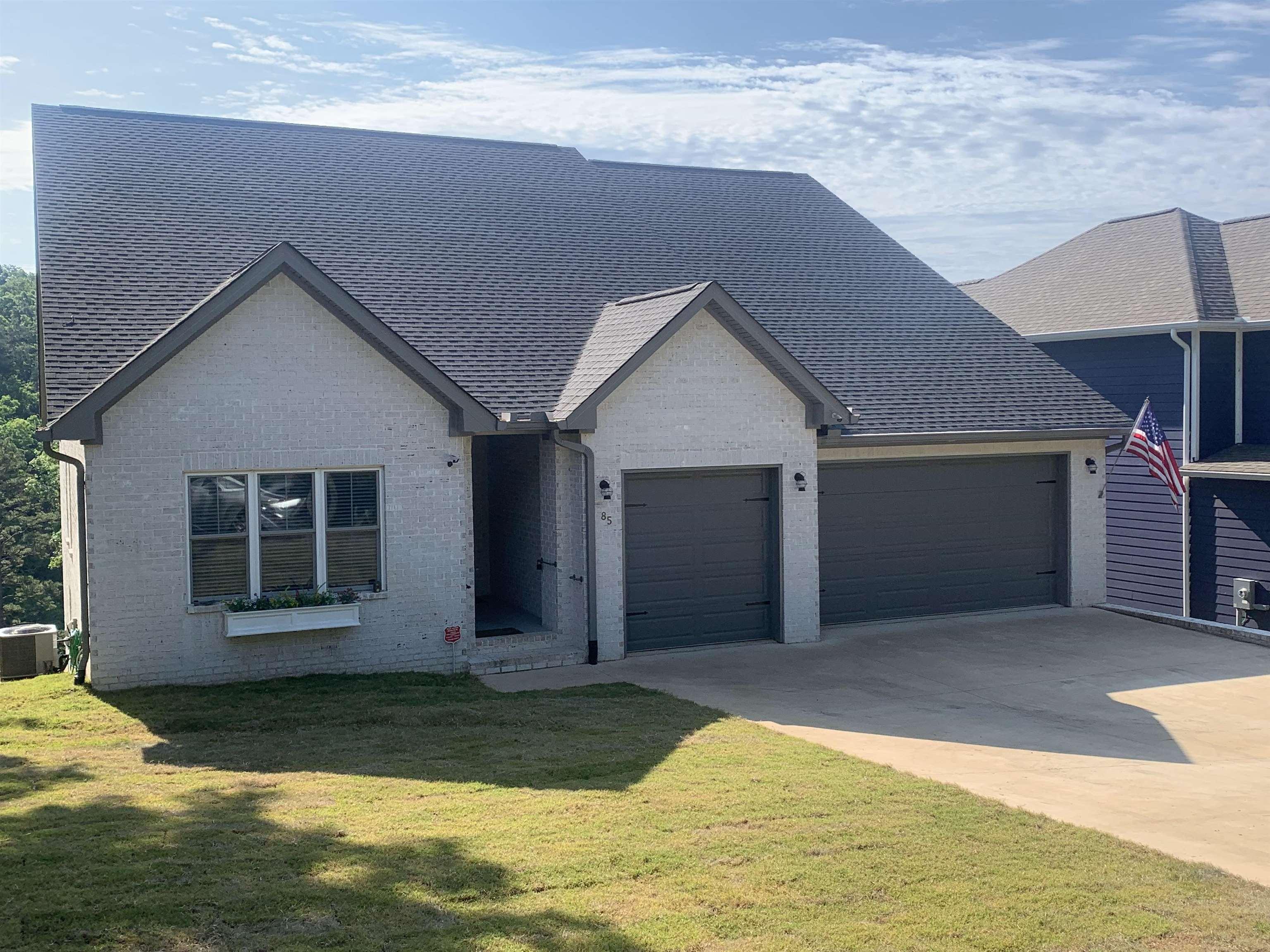 Image 1: White brick exterior with dark gray trim details